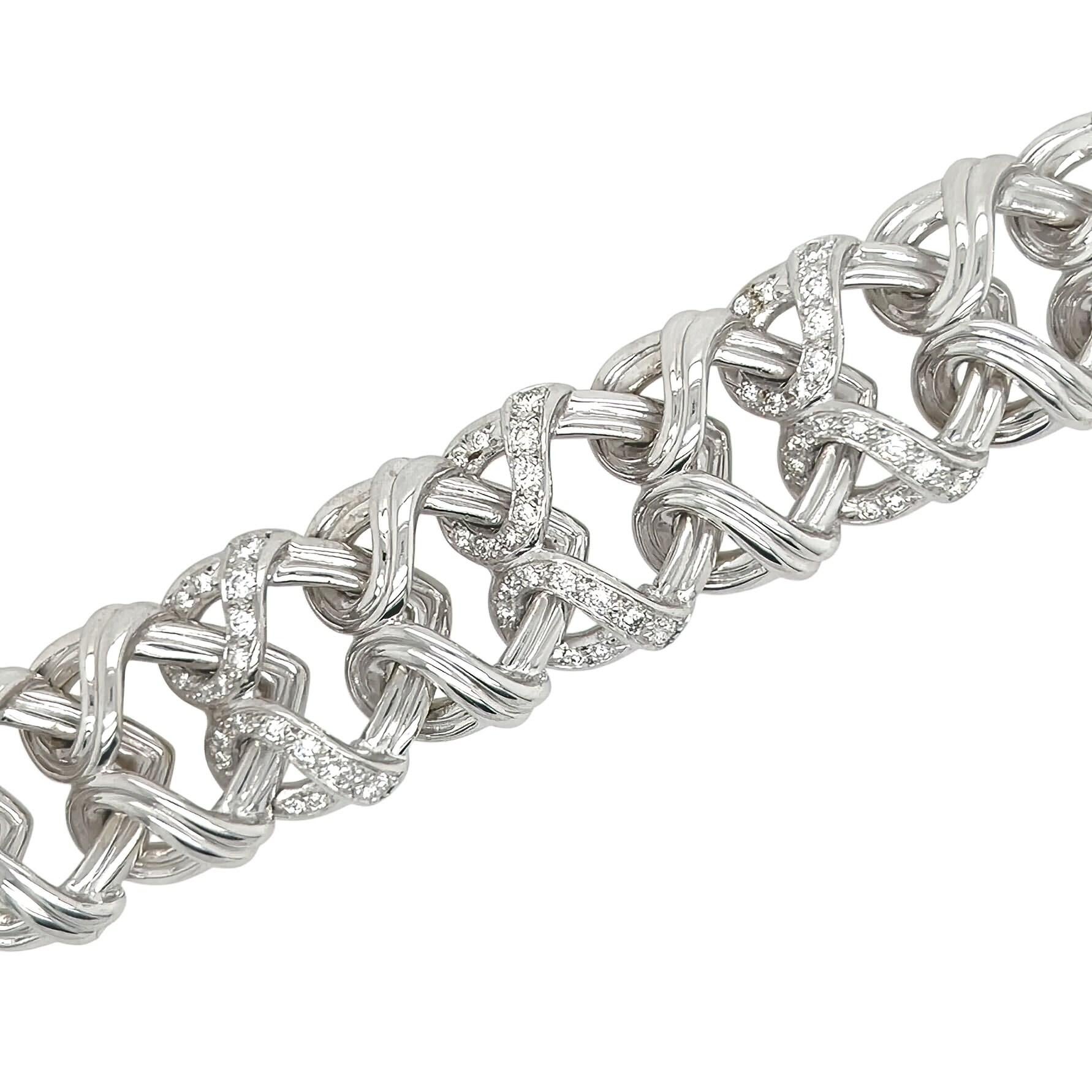 Una pulsera de oro blanco de 18 quilates, platino y diamantes, Verdura.  El brazalete de oro blanco está diseñado como una longitud de motivos de corazones entrelazados, los tres motivos centrales realzados con aproximadamente 54 diamantes redondos