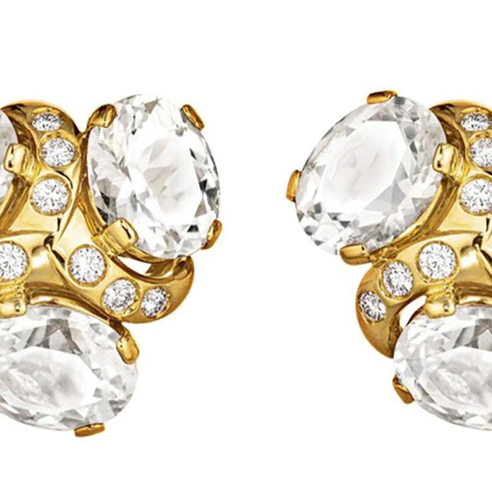 Verdura combines colorless stones and 18k yellow gold to produce these statement cluster ear clips. Eighteen round brilliant cut diamonds dance around the six faceted oval topaz creating movement and brilliance.

Length is approximately 0.80 inches