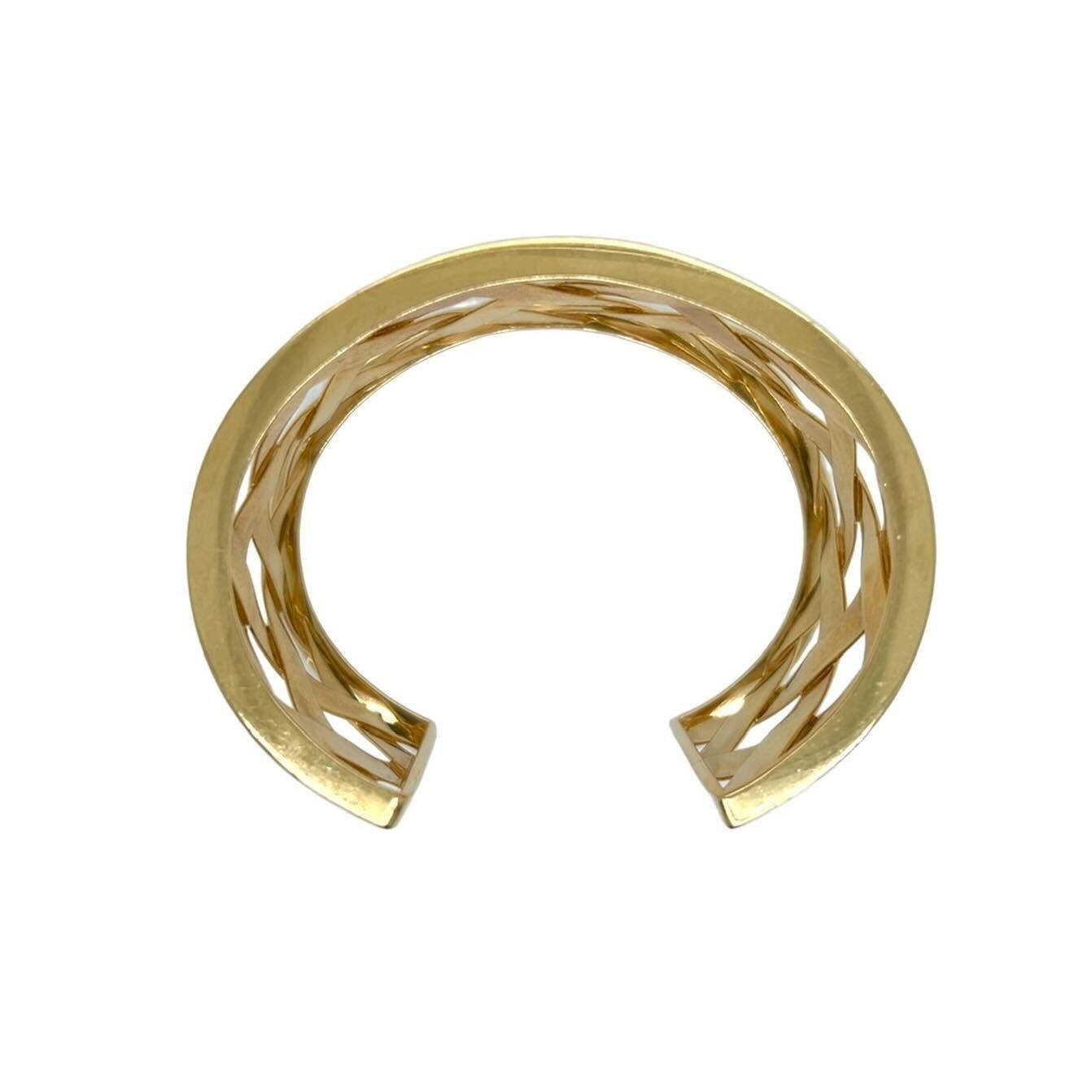 An 18 karat yellow gold bracelet, Verdura.  The “Criss Cross” cuff designed as a wide, open backed cuff of lattice woven gold.  Inner circumference approximately 6 inches.  Gross weight approximately 66.30 grams.  Signed Verdura and hand numbered