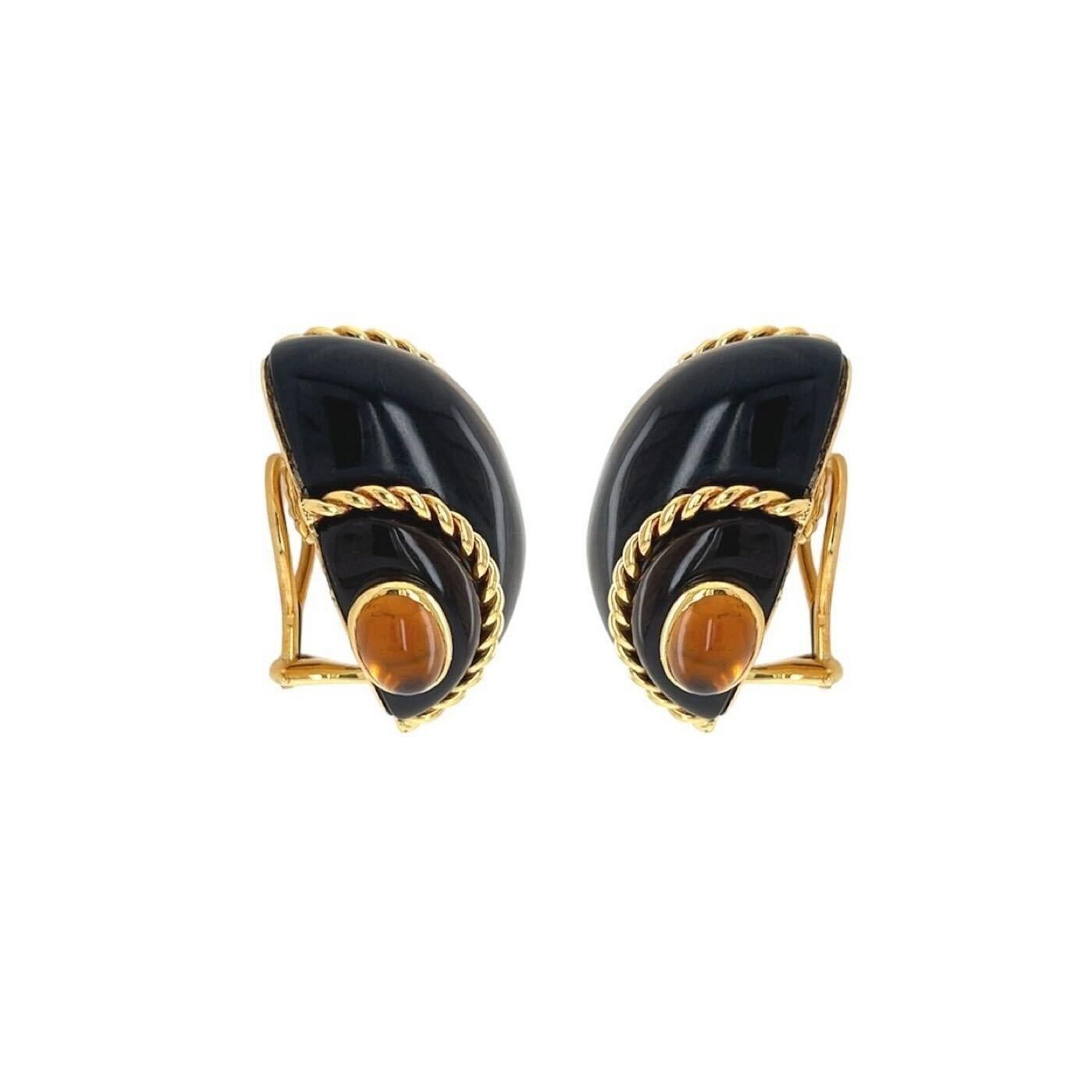 A pair of 18 karat yellow gold, tiger’s eye and citrine earclips, Verdura.  Each earclip designed as a turbo shell of tiger’s eye applied with ropetwist wire and completed by two (2) terminals of bezel set oval cabochon citrines measuring