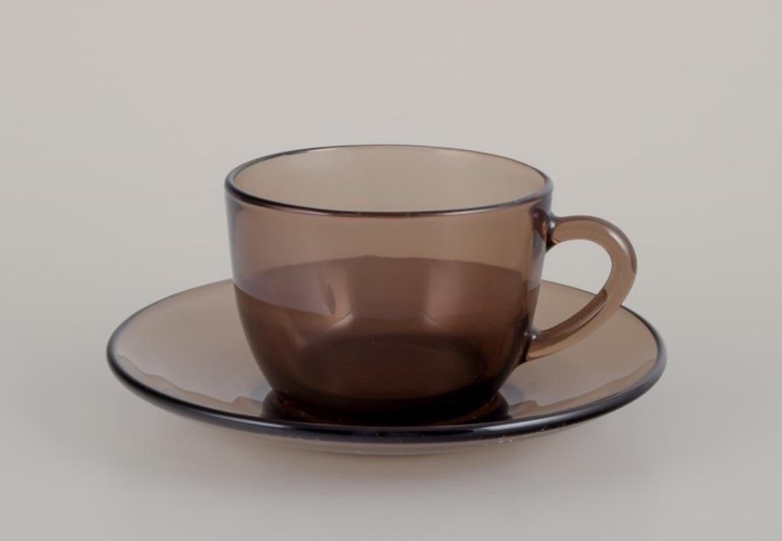 Vereco, Frankreich. Ein Set aus vier Kaffeetassen und Untertassen aus geräuchertem Kunstglas.
1970s.
Markiert.
Perfekter Zustand.
Tasse: D 7,5 cm ohne Henkel x H 5,5 cm.
Untertasse: 13,2 cm.