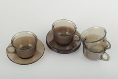 Vereco, France. Set of four cups and four saucers in smoked glass. 1970s.