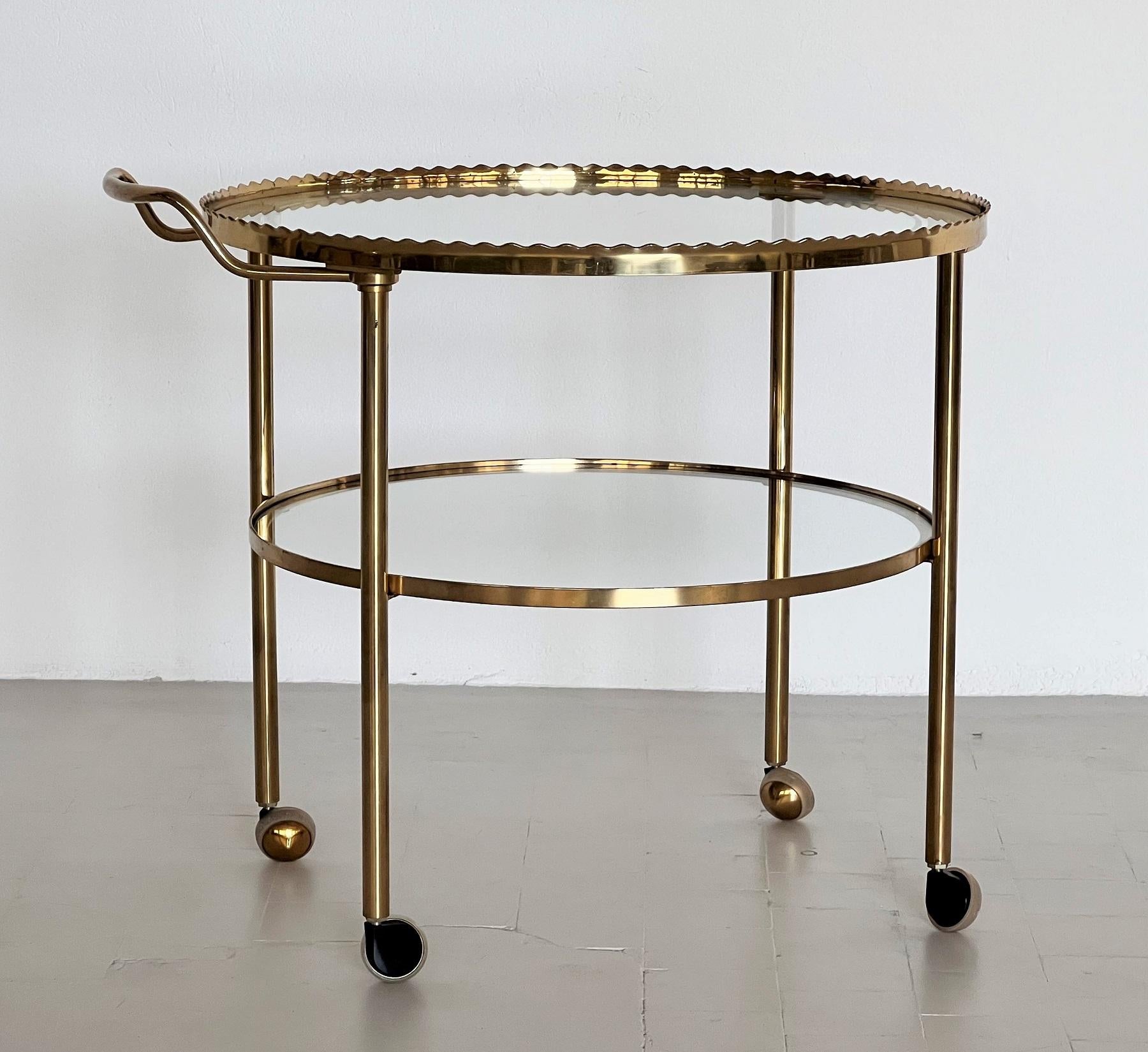 Vereinigte Werkstatten-Wagen- oder Barwagen aus Messing und Glas aus der Mitte des Jahrhunderts, 1970er Jahre

Wunderschöner eleganter Servierwagen oder Barwagen aus den 1970er Jahren mit vier Rädern.
Das Schöne an diesem Wagen ist die Form des