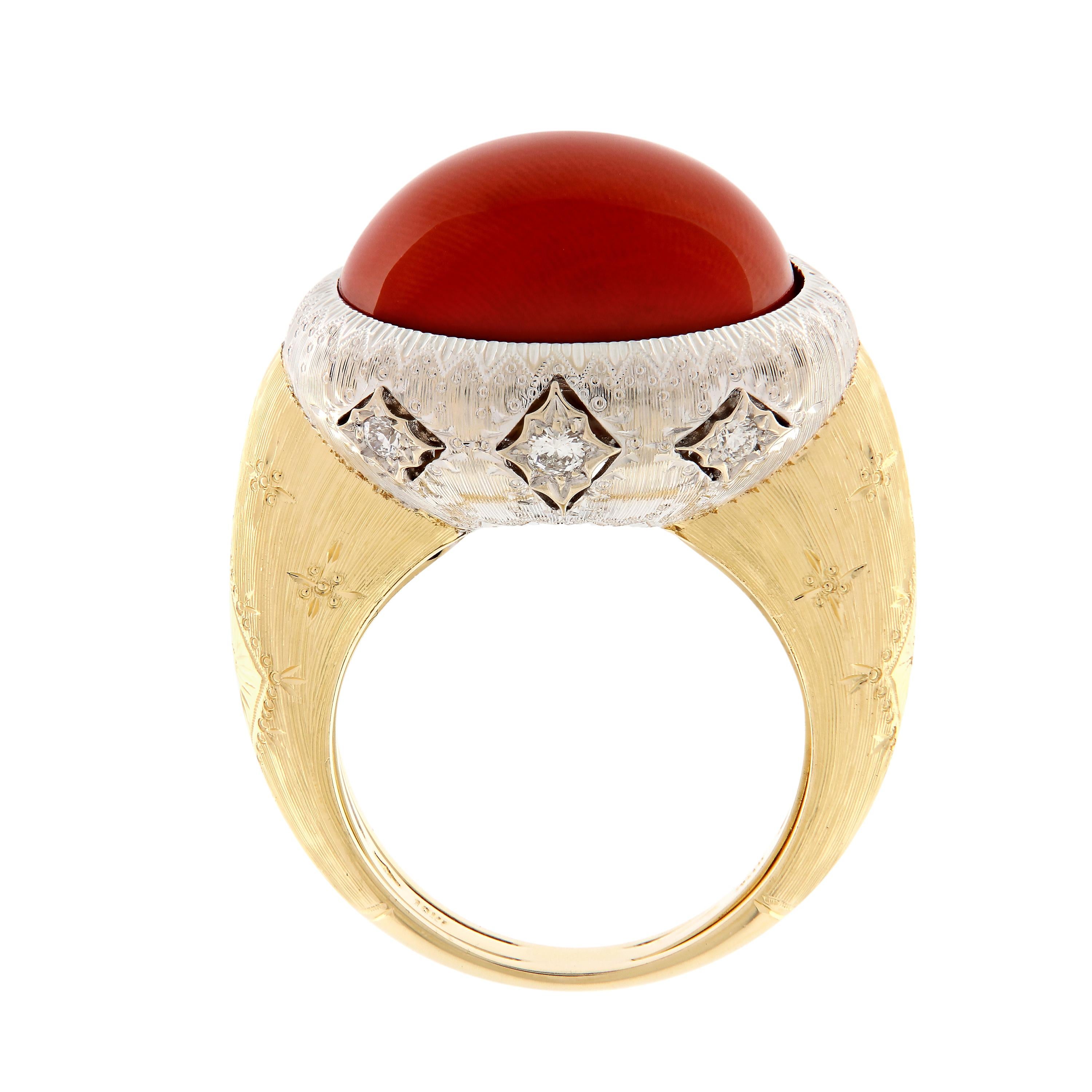 This statement ring features a beautiful round coral accented with six diamonds and artfully placed in a setting of 18k white and yellow gold. The ring has a beautiful Florentine finish and is an outstanding display of color and Italian