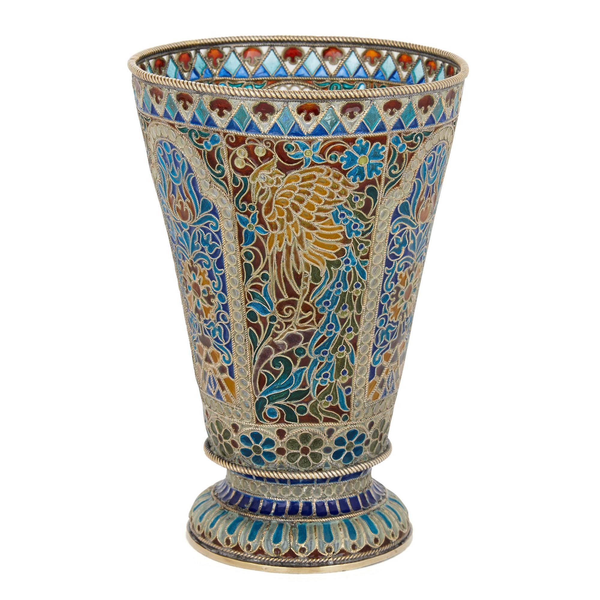 This Russian decorative beaker is crafted from vermeil (silver-gilt) and plique-à-jour enamel. The cylindrical beaker tapers from top to bottom, the body of the beaker formed from filaments of Fine twisted vermeil wire, between which is inset clear,