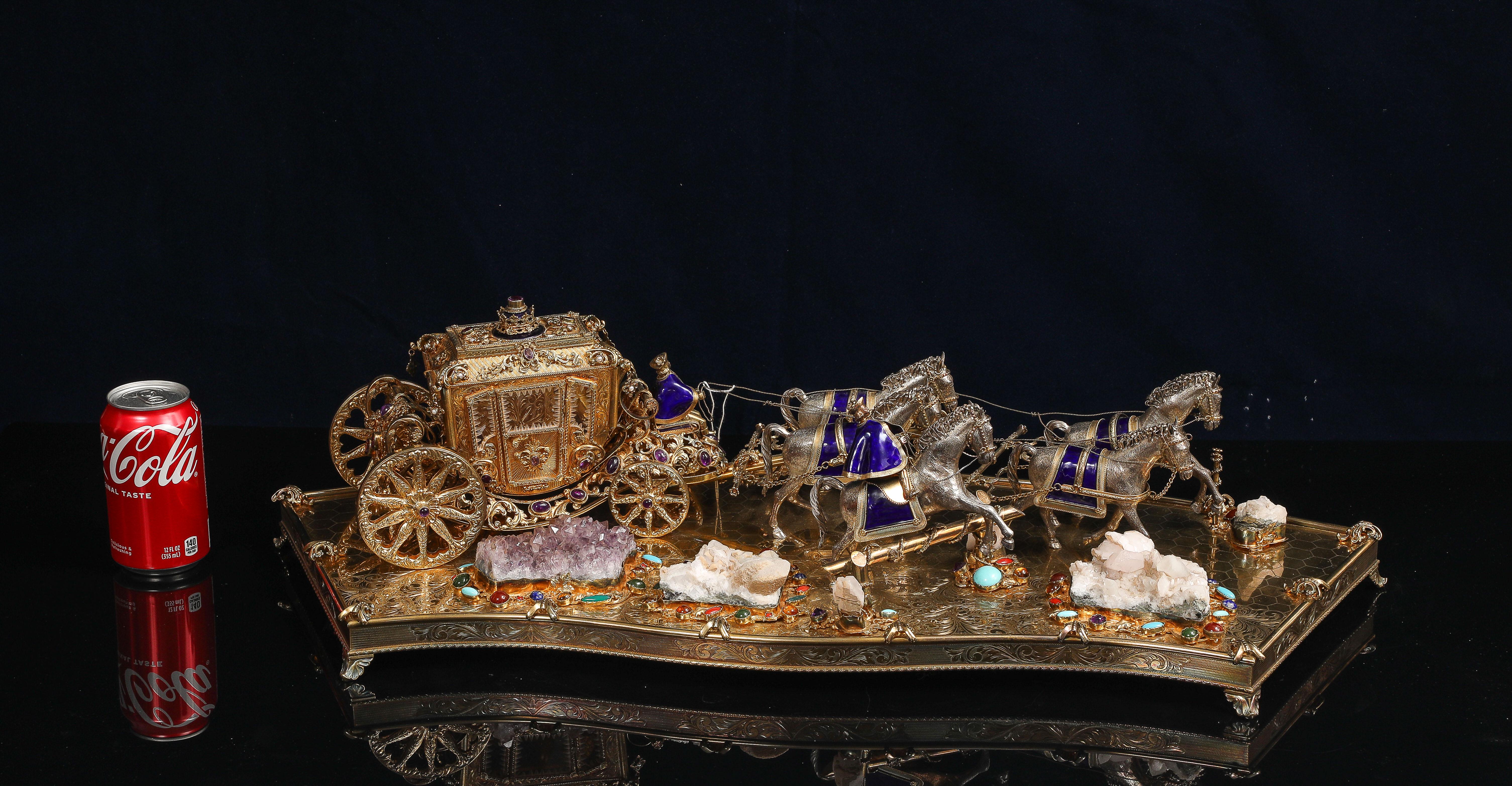 Un'incredibile carrozza austro-ungarica in vermeil (argento dorato) e pietre preziose con cavalli in argento smaltato e cocchiere a cavallo.  La composizione presenta un carrello in vermeil montato su una base dorata sagomata, con incastonate varie