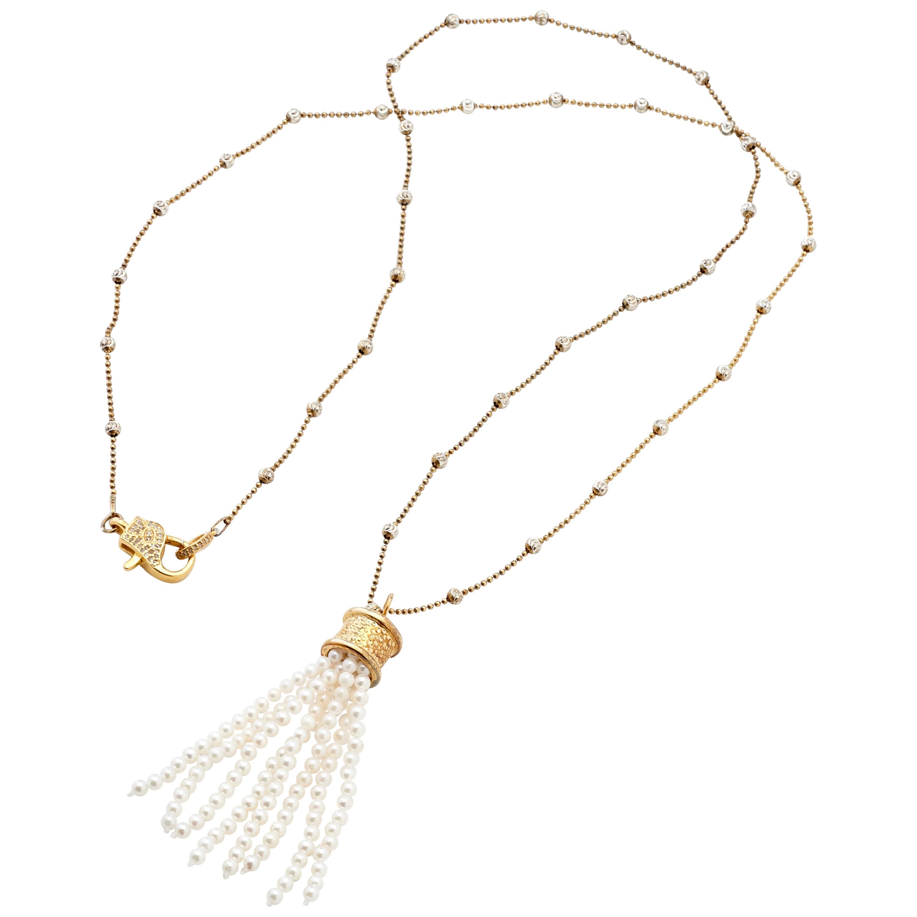 With an elegant fresh look, this beaded chain of fourteen karat yellow gold on sterling silver leads to a flirty tassel pendant with over 130 hand-strung 2-1/2mm genuine Akoya Pearls. The sterling beaded stations are cut with a half moon ridge