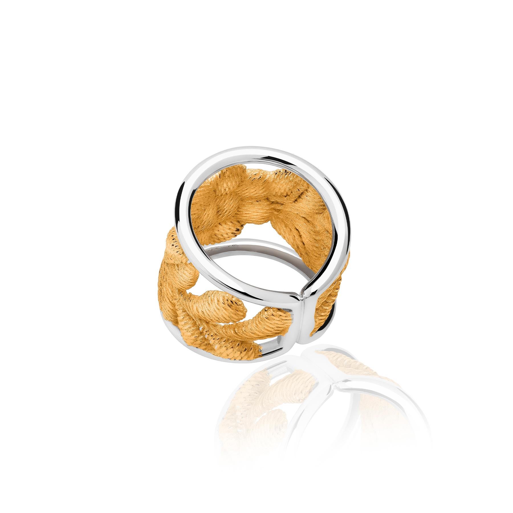 The Bordados Vermeil Ring from the Bordados Collection by TANE is made in sterling silver with 23 karat yellow gold vermeil. The piece consists of two shiny silver rings that hold the floral embroidery that have been detached from the textile to, as