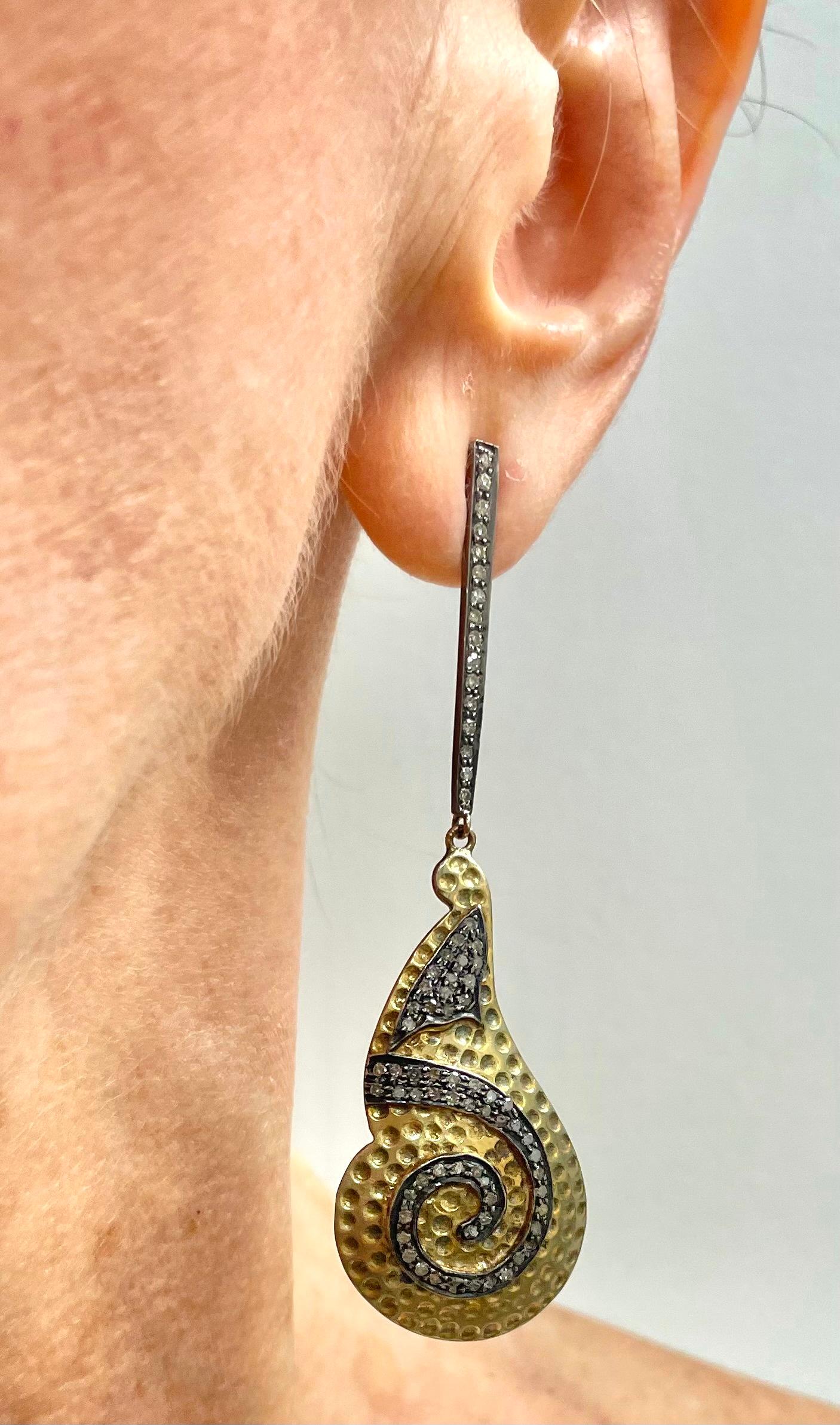 Description
Striking hammered 14k yellow gold vermeil with a swirl of pave diamonds for contrast and style, suspended from a tapered pave diamond bar post.
Item # E3121

Materials and Weight
Vermeil
Pave diamonds 1.90cts
Rhodium sterling silver
14k