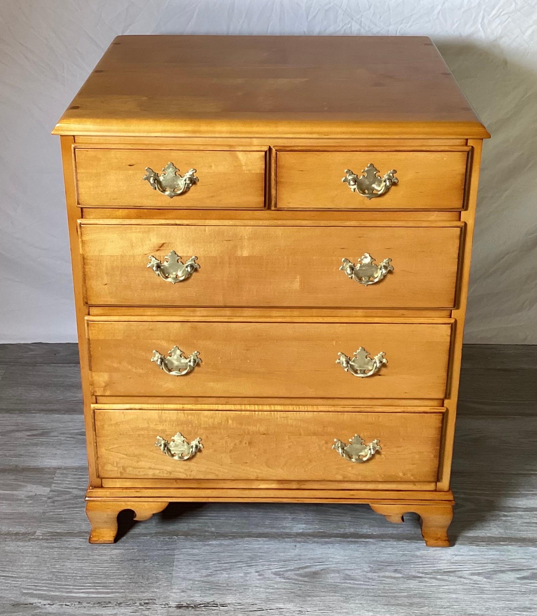 Beautiful solid Vermont maple chest of drawers.  The chest with classic Aladdin's lamp brass hardware in a warm buttery maple wood. Two smaller drawers over three larger drawers with the chest resting on bracket feet.  The finish has been