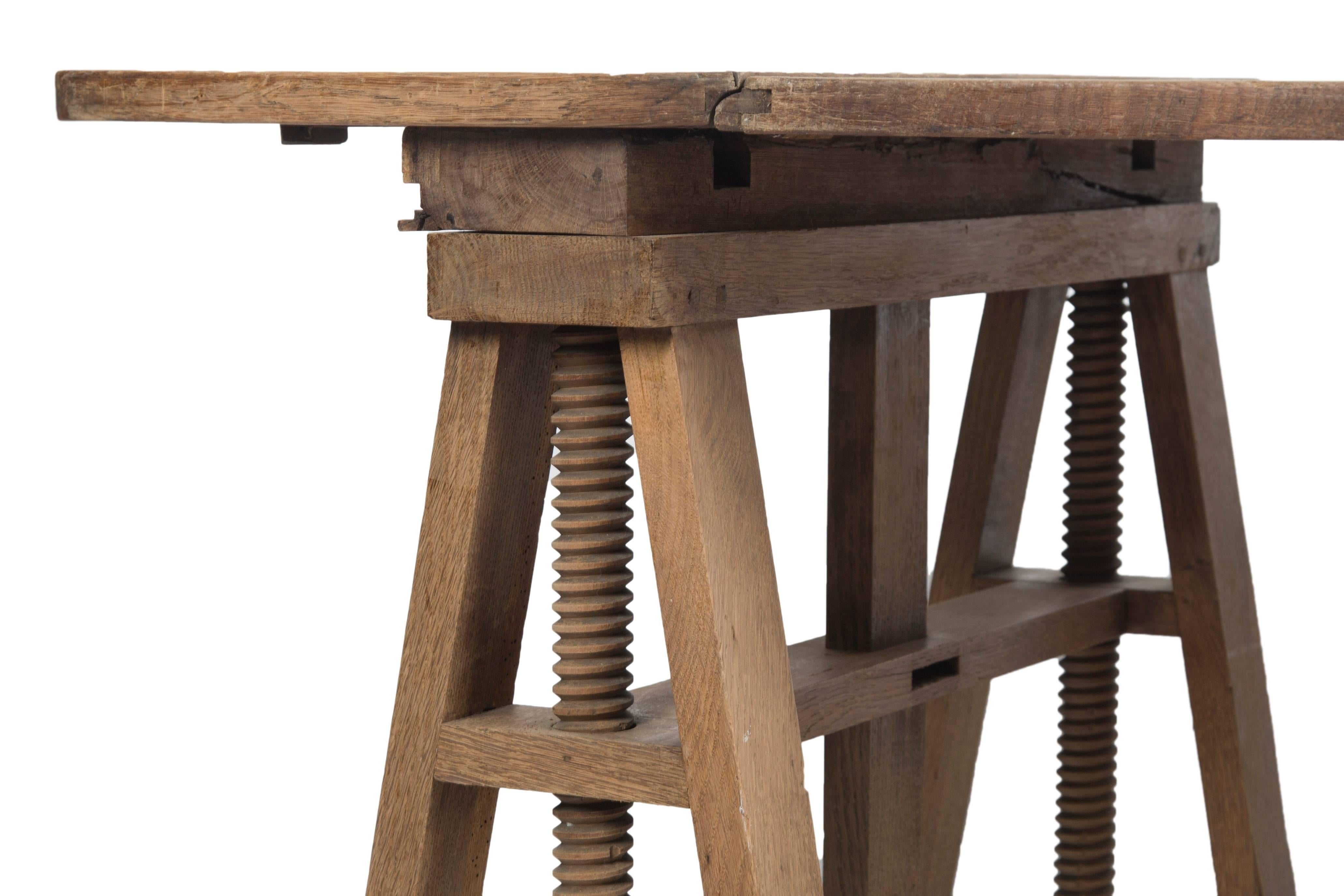 Early 20th century Vernacular adjustable artist’s trestle table. The unfinished oak having a good oxidized natural patina. These types of tables would hold art and sculpture for display in a studio environment.