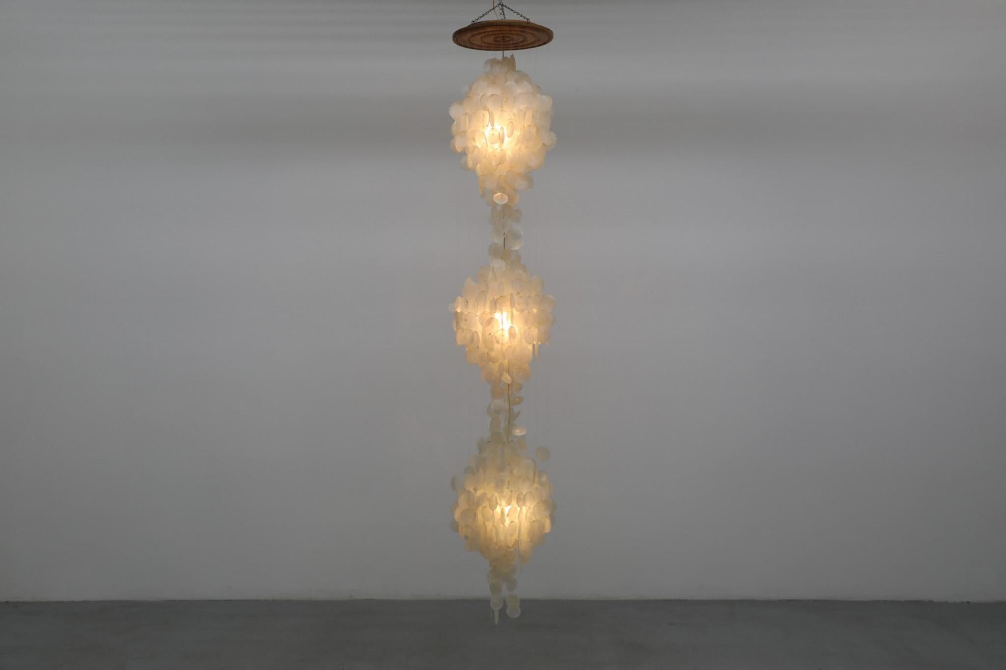 Stupendo lampadario a cascata con conchiglia capiz extra large e baldacchino in legno. Nello stile dell'icona del design danese Verner Panton, ma con una bellezza individuale e distinta che la colloca in una categoria a sé stante. La scala imponente