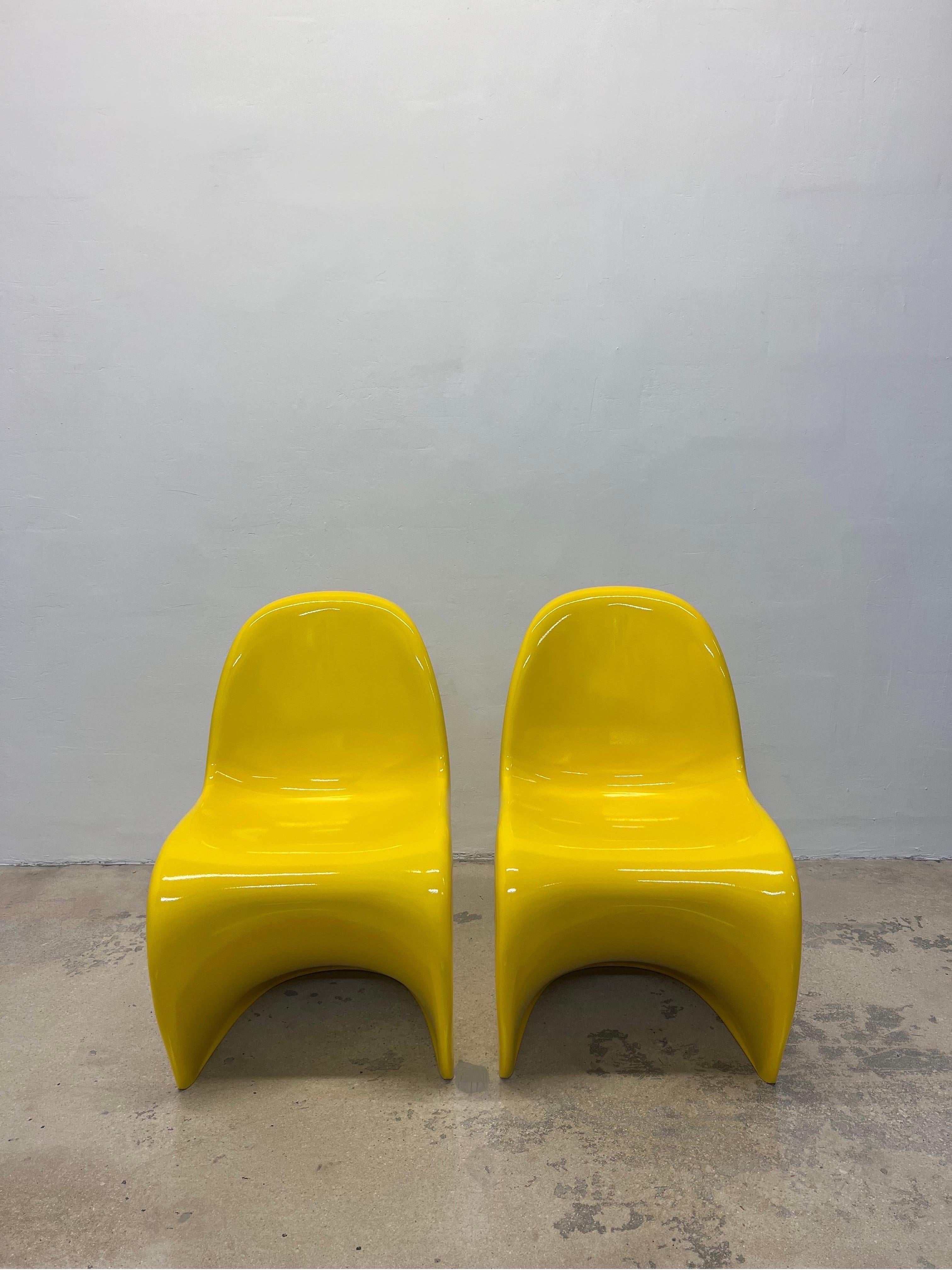 Second generation S chairs rendered in molded Polyurethane rigid foam and re-finished in bright sunshine yellow lacquer. Originally designed by Verner Panton in the 1960s, this pair was manufactured by Vitra in the early 1990s.