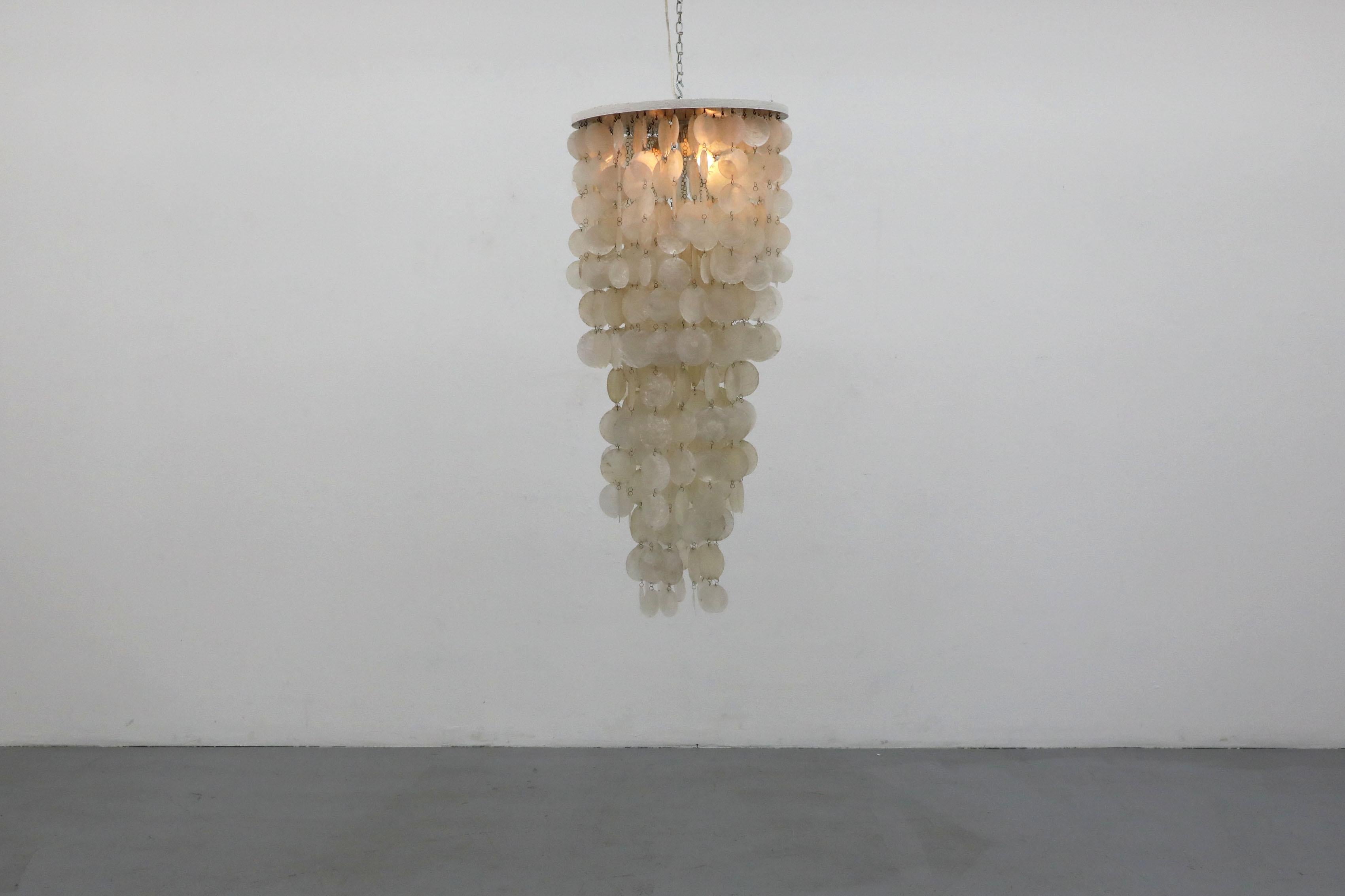 Beautiful multi-tiered capiz shell chandelier with wood and metal canopy. Impressive and eye-catching, this Italian piece in the style of Great Dane Verner Panton is sure to elevate the space it's in with its softly reflective surfaces and its