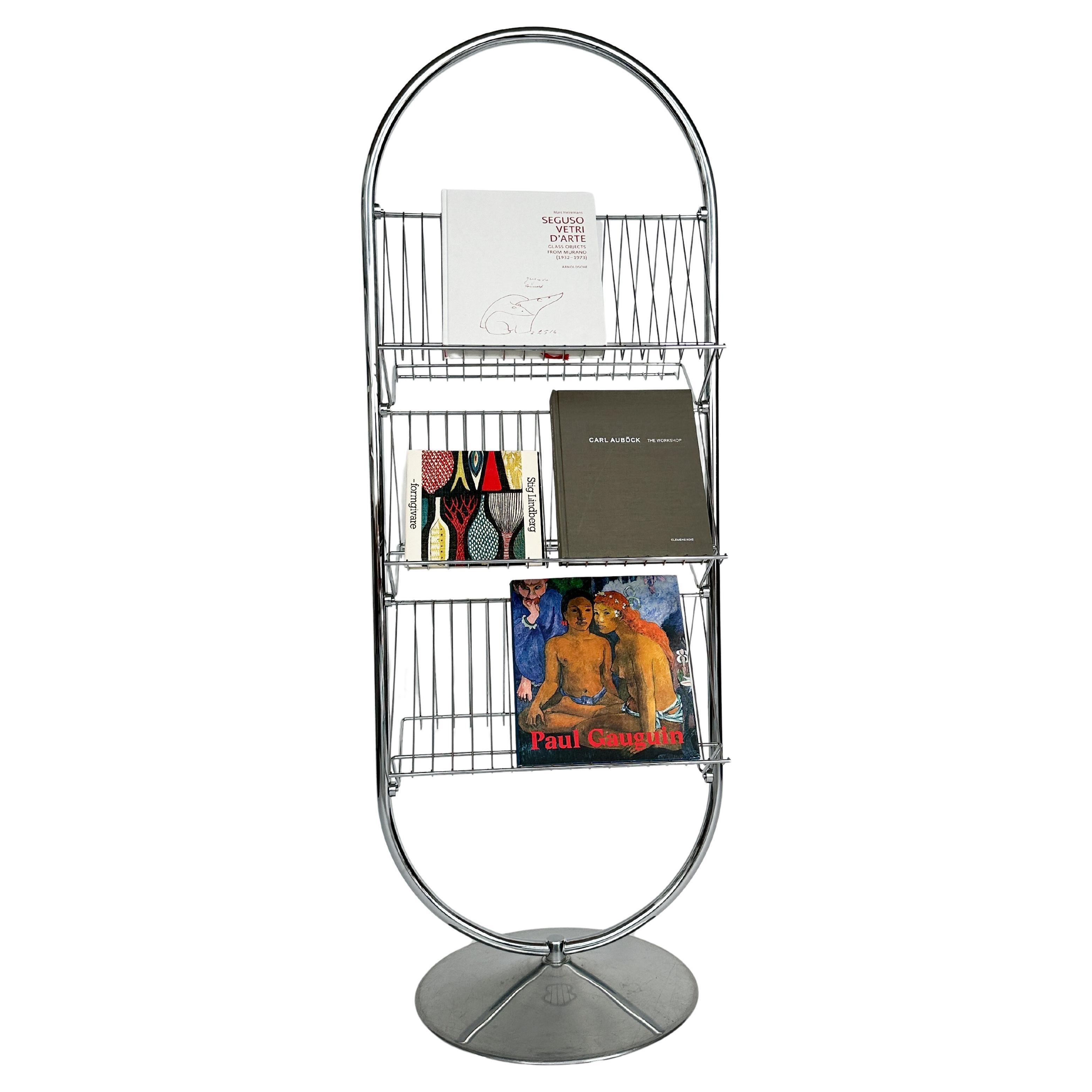 Iconic Verner Panton magazine rack for Fritz Hansen, designed in 1973.

Double sided chromed steel racks on cast aluminum base.

Marked with the Fritz Hansen sticker on base.

Height: 160 cm
Width: 59 cm
Depth: 40 cm

Good condition with scratches