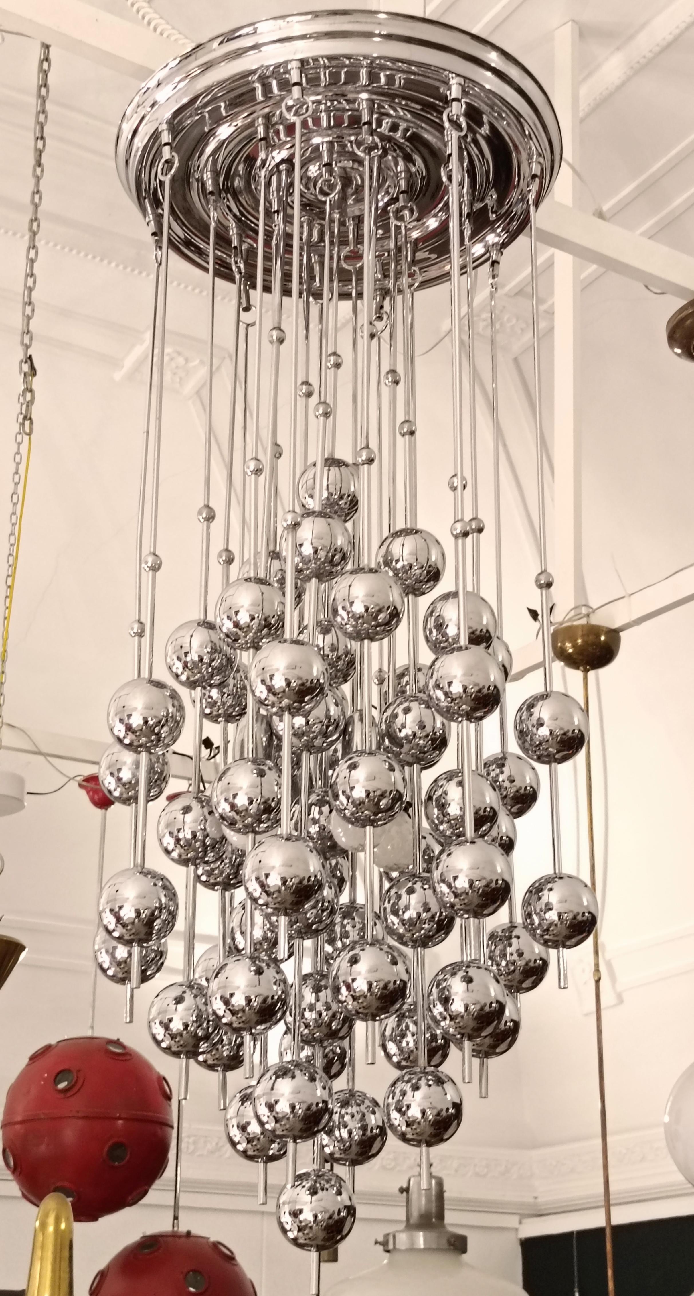 Rara lámpara de araña Mod. Bola diseñada por el danés Verner Panton para J. Lüber durante los ilustres años setenta. Suspendidas graciosamente de varillas de acero, hay  pajitas cromadas adornadas con bolas de metal.