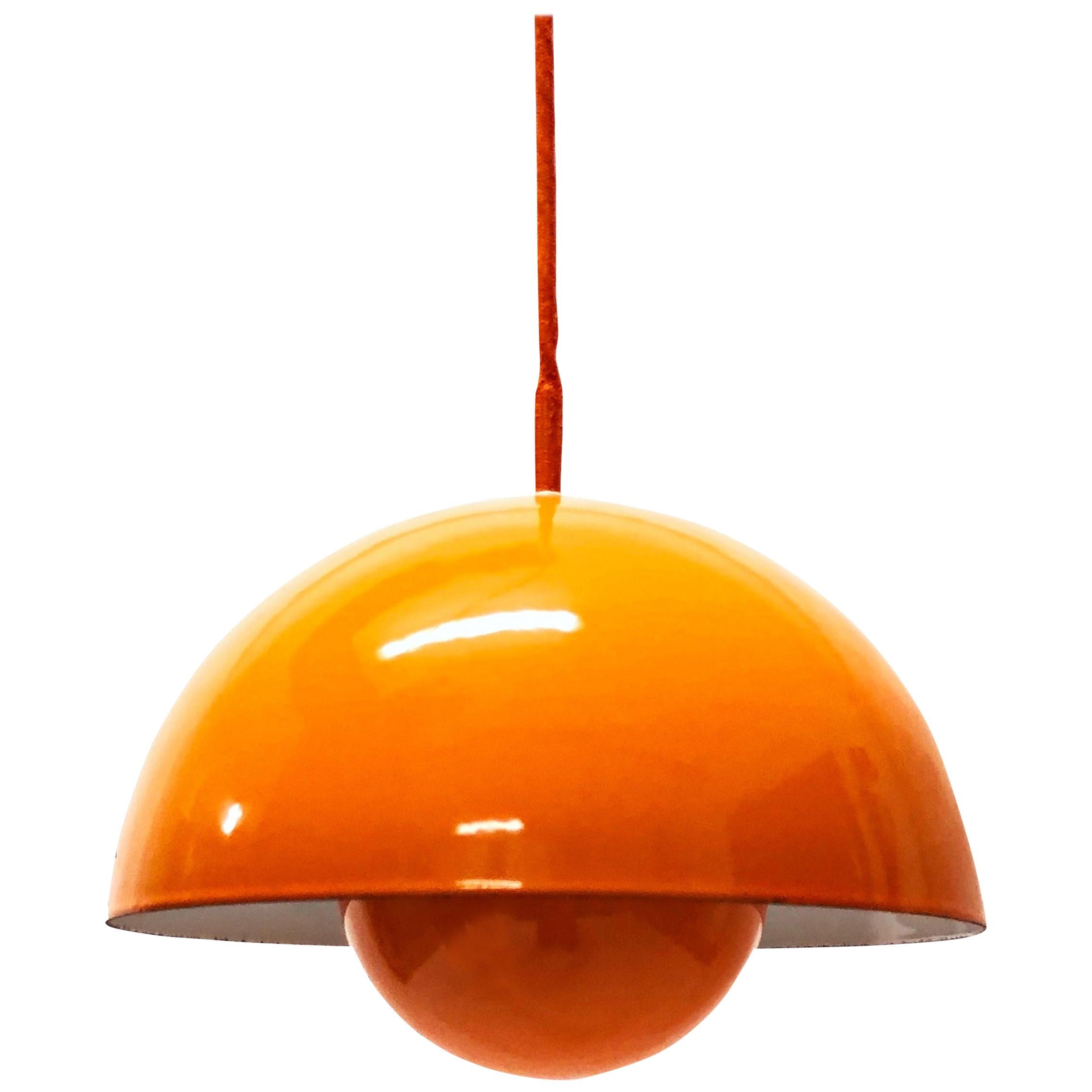 Verner Panton flowerpot pendant lights designed for Louis Poulsen in 1969.

This set of two yellow pendant lights are an early example of the Panton flowerpot model and feature an orange enamel lampshade consisting of two semi-circular spheres