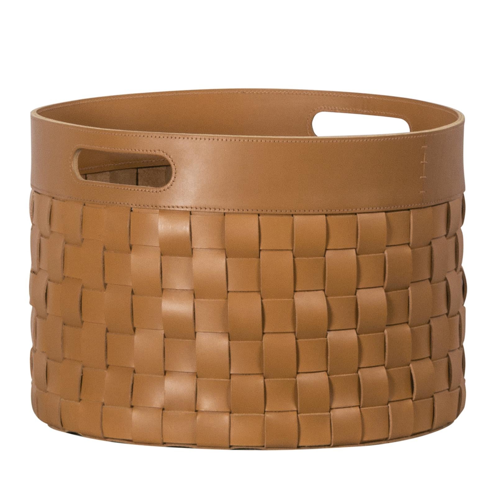 This exquisite storage basket is a precious object that is both functional and striking, thanks to the fine leather that has been dyed using vegetable fibers. The thick strips of leather are woven to create a unique texture, enhanced by the warm