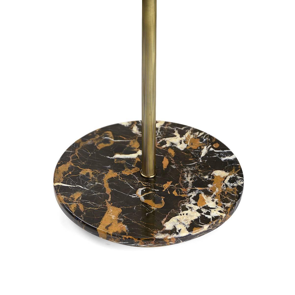 This striking floor lamp effortlessly mixes modern and traditional materials, for an object of functional decor that will be suitable for both classic and contemporary interiors. The metal structure is adorned at the base with a round marble