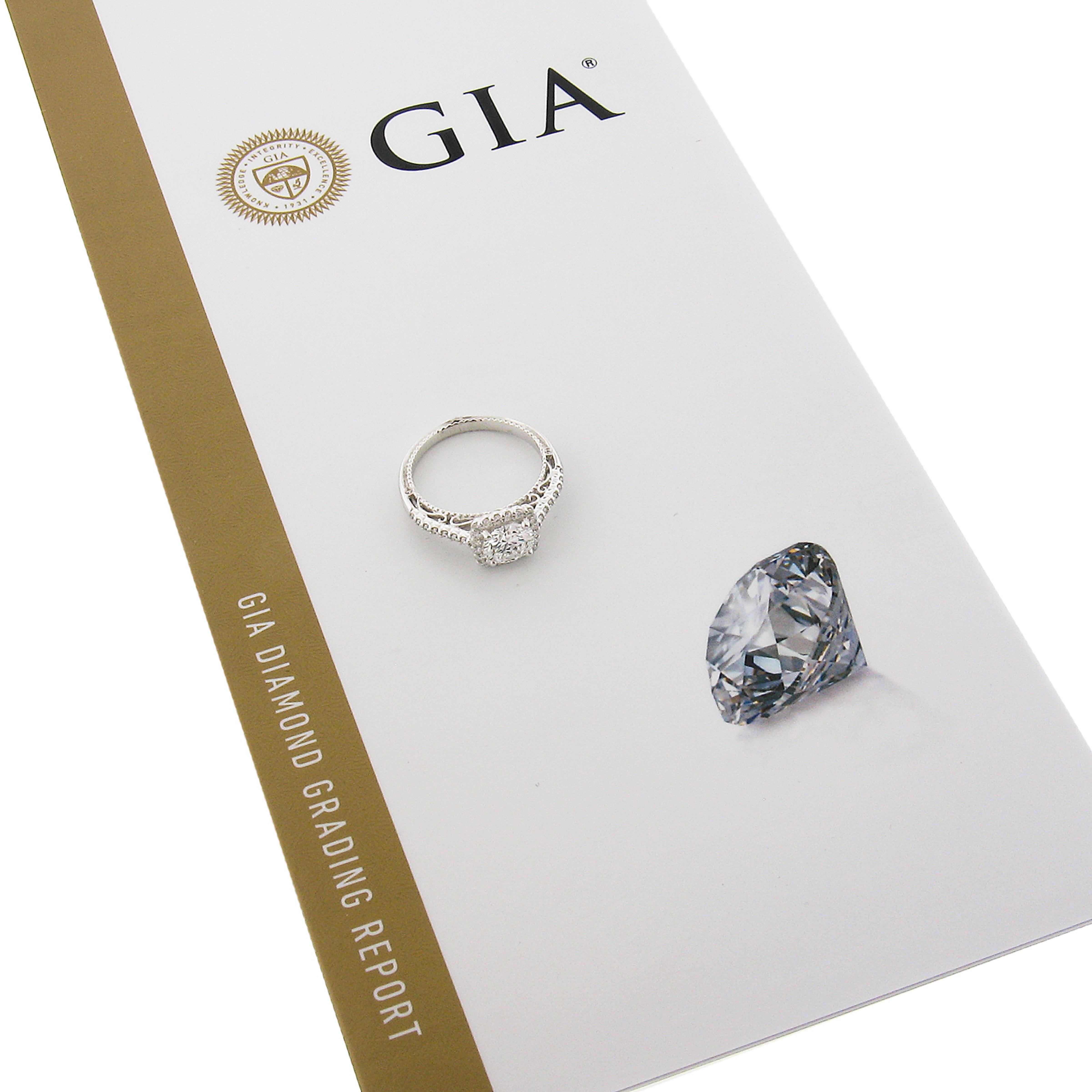 Cette élégante et chic bague de fiançailles en diamant de Verragio est fabriquée en or blanc massif 18 carats et présente un magnifique solitaire en diamant rond de taille brillant certifié par le GIA. Ce diamant central est de très haute qualité