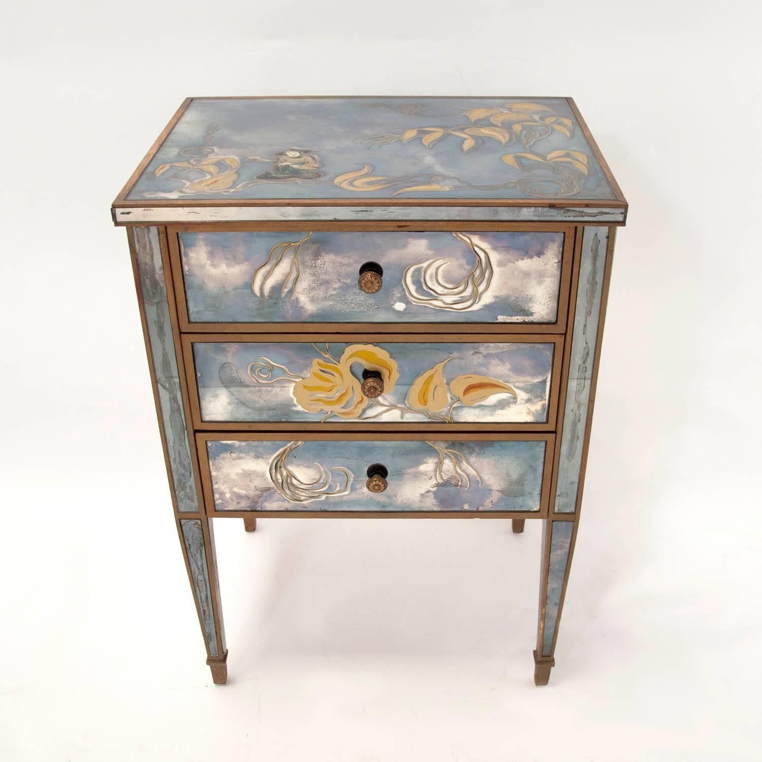 A 1940s Hollywood Regency antique mirrored nightstand or side table with three drawers in the style of Jansen. Silvered wood frames and reverse hand-painted églomisé designs of tropical foliage and an Asian figure. Back is mirrored as well.
 