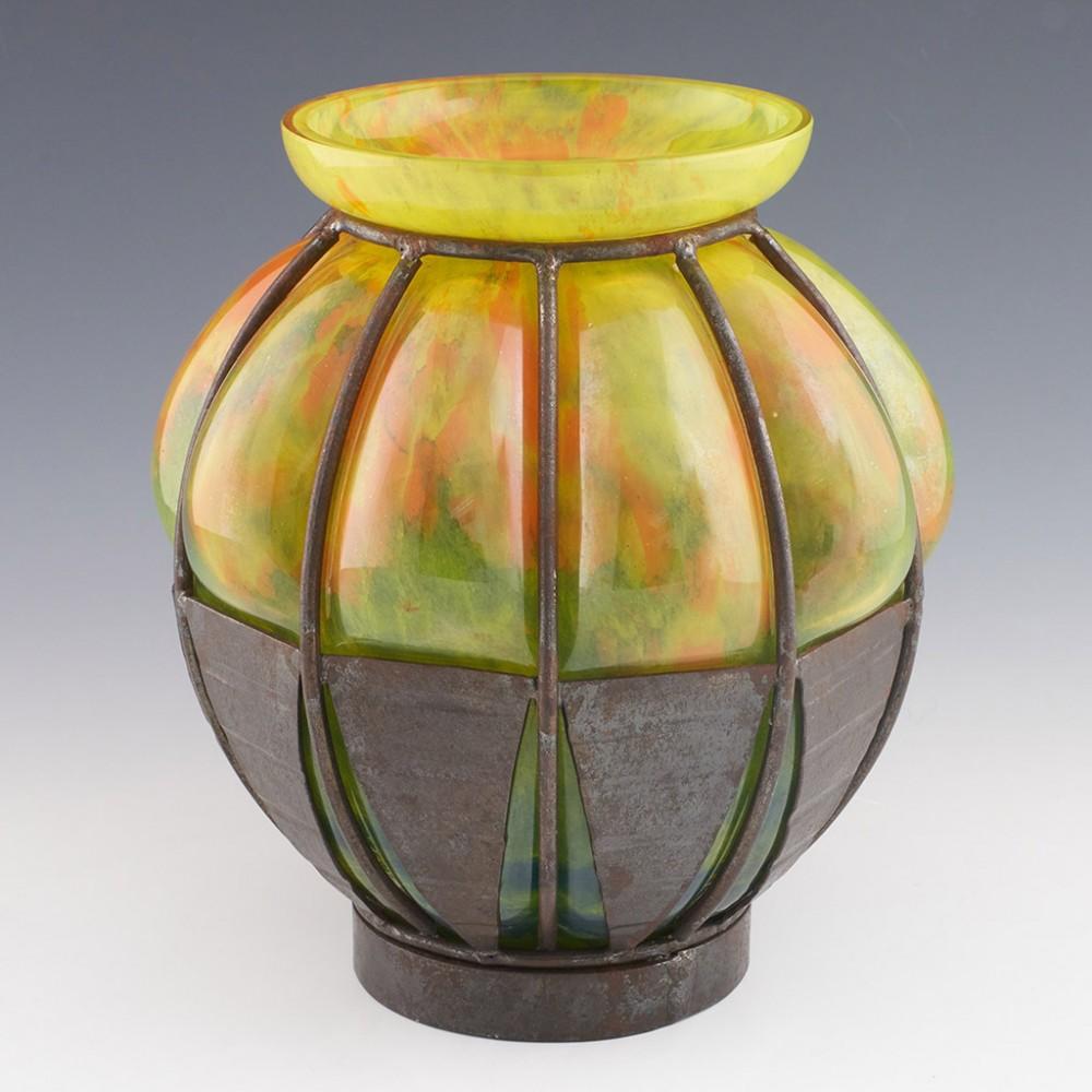 Heading : A Verrrerie d'Art Lorrain vase with Majorelle type wrought metal mounts
Date : Circa 1925
Origin : Croismare, France
Bowl Features : Mottled citrus coloured glass blown into metal armature
Marks : Unmarked
Type : Lead glass
Size : Height