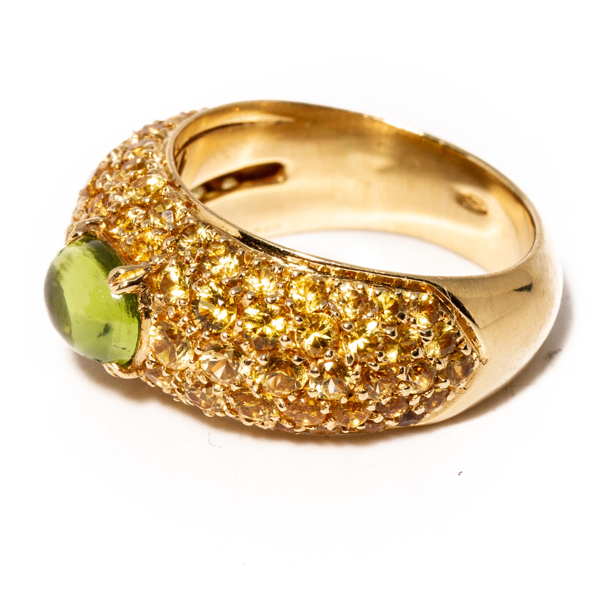 18k gold half band ring by Versace. Set with yellow gemstones and cabochon peridot - 7.7mm x 5.8mm. Measures - 7, ring band is 10mm at widest point. Weight 10.2 grams. Marked Gianni Versace 750 GV.