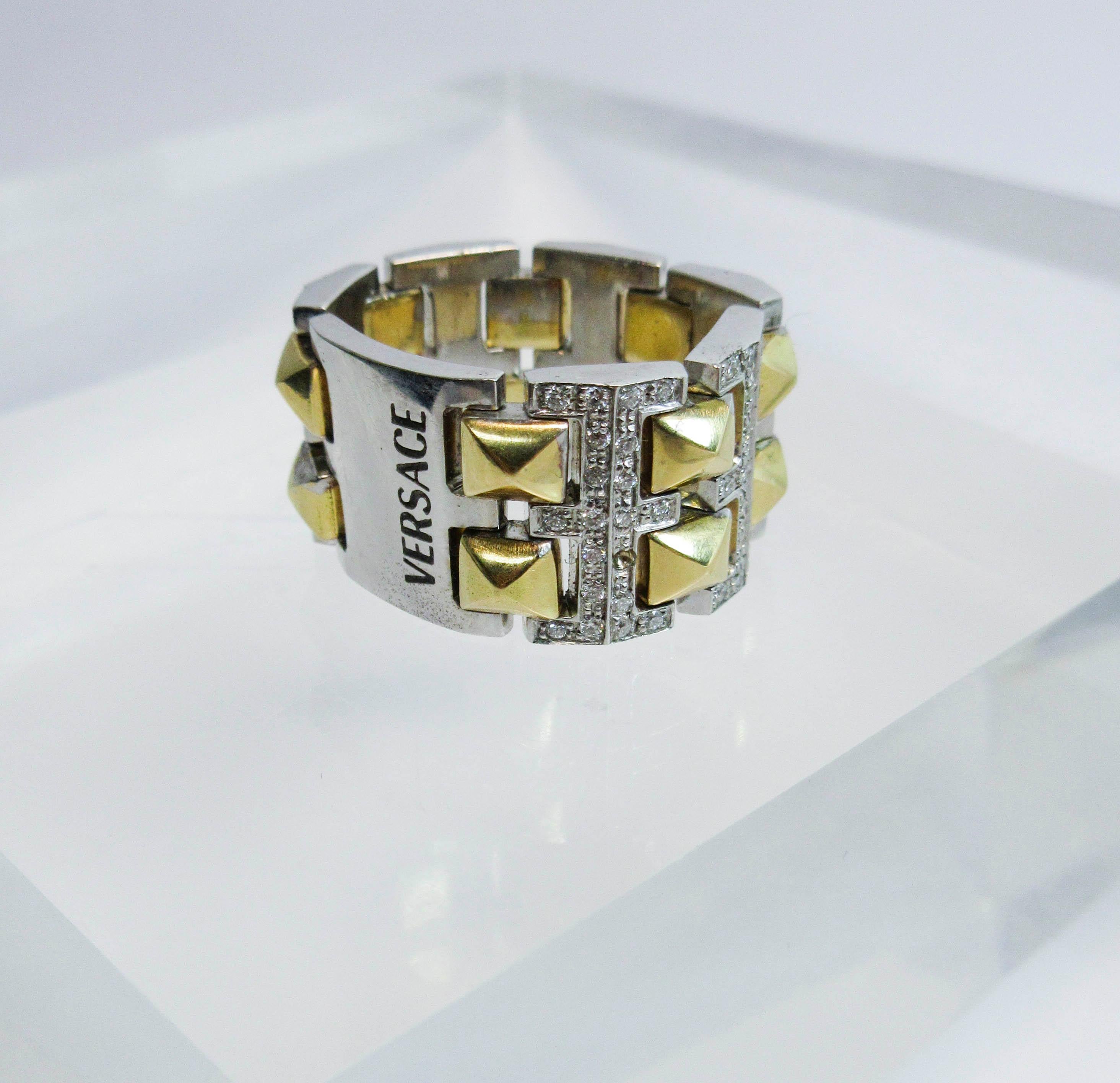 This Versace design ring is composed of white and yellow gold, and features approximately 0.60cts of diamonds.  Size 6. Please feel free to ask us any additional questions you may have.