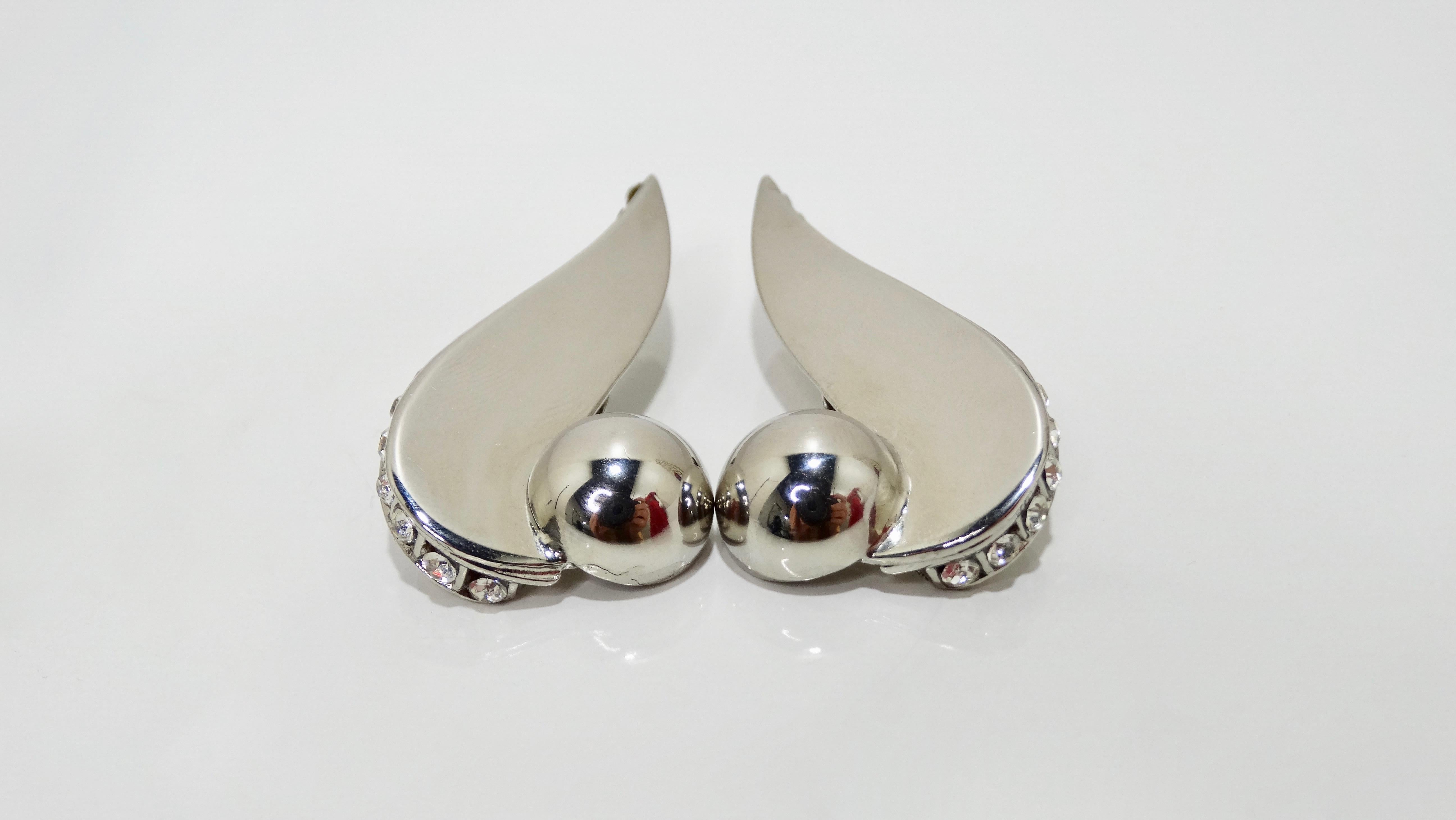 Get some Versace in your life! Circa 1980s, these silver tone earrings are the product of Ugo Correani who worked alongside Gianni Versace to create costume jewelry. They feature a geometric shape with a rhinestone embellished trim and clip-on