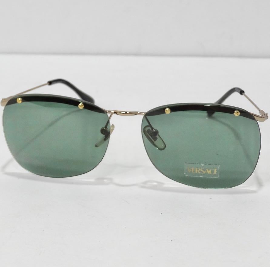 Ces lunettes de soleil de Versace, datant des années 1990, sont vraiment superbes ! Les lunettes de soleil parfaites de style aviateur sont dotées de verres bleu verdâtre, de détails noirs et d'accents dorés. Ce sont les lunettes de soleil parfaites
