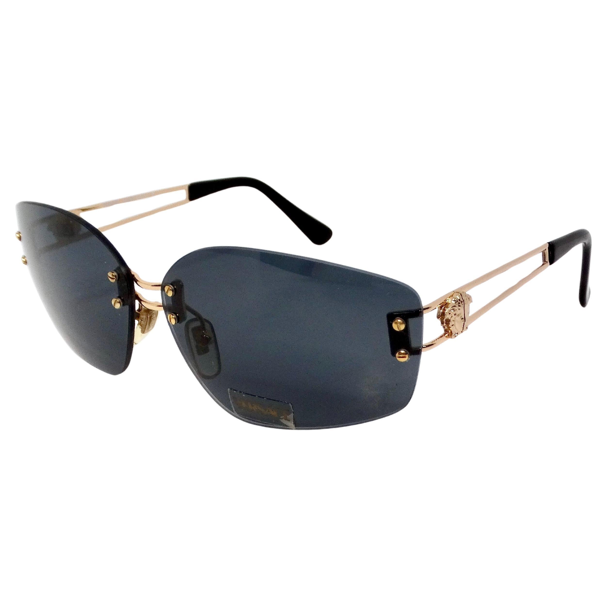Step into a timeless era of fashion with the Versace 1990s Dark Blue Tinted and Gold-Tone Metal Rectangular Sunglasses. These iconic sunglasses encapsulate the opulence and boldness synonymous with Versace, featuring luxurious dark blue tinted