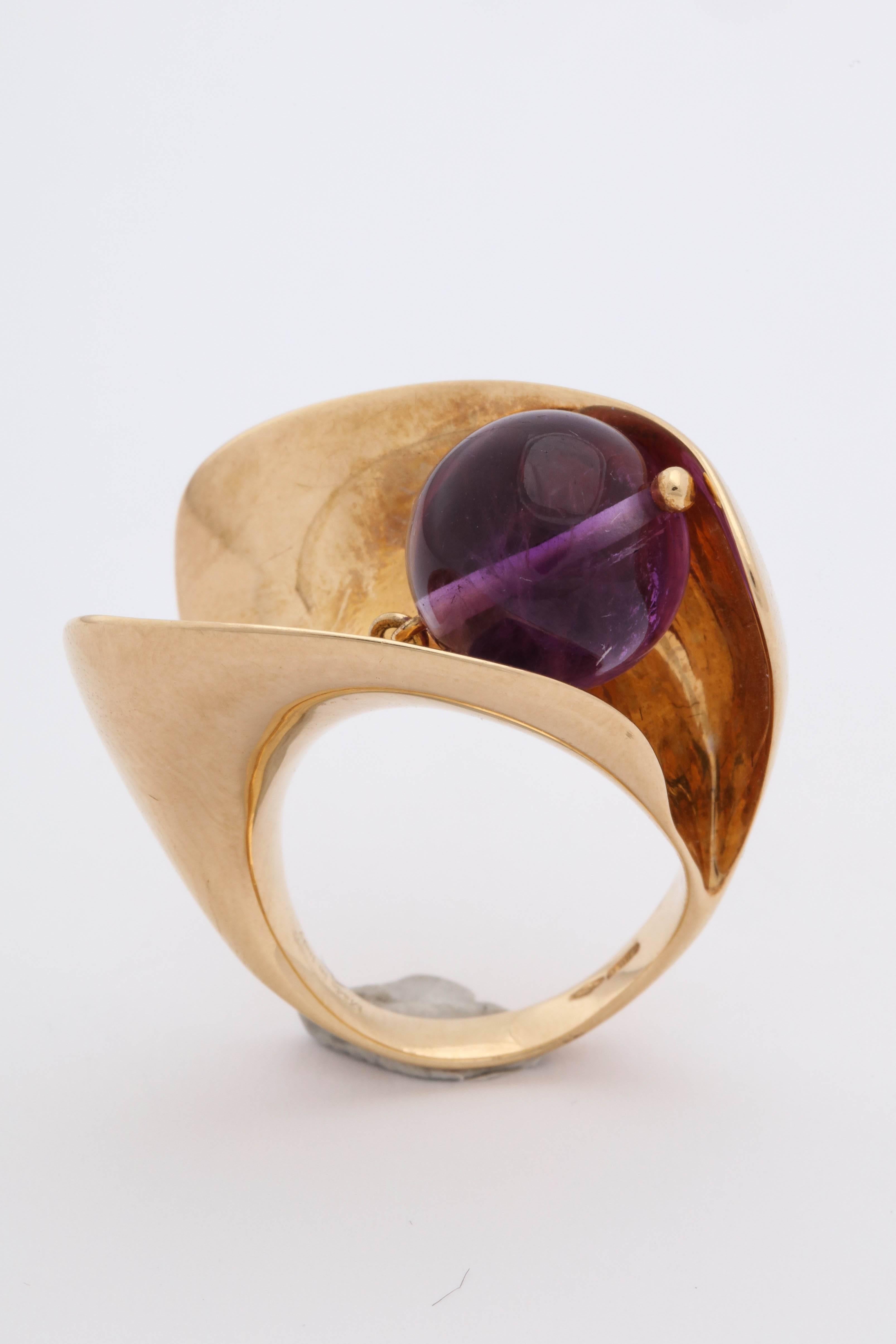 One Ladies Very Cool And Hip 18kt Yellow Gold Sculptural Wave Cocktail Ring Designed With One Moveable And Swivel Amethyst Bead Measuring Approximately 11MM. This Fun Ring Is Designed By Versace,In The 1990's In Italy. Current ring size Is = 7 May