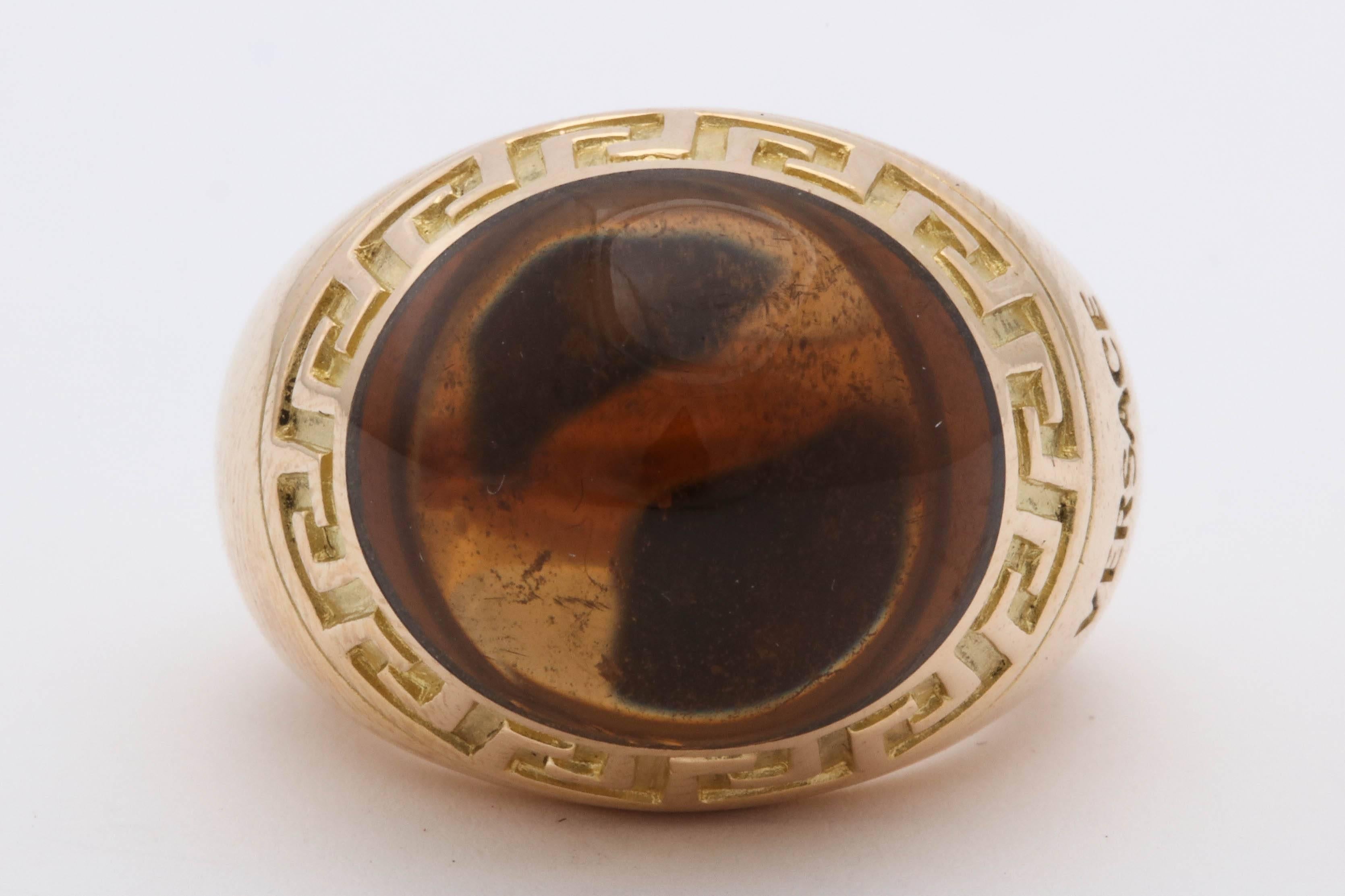 One Unisex Ring Heavy 18kt Yellow Gold Ring Designed With a Signature Greek Key engraving Around The Large Cabochon Sugarloaf cut Honey Color Citrine,Citrine Weighing Approximately 20 Carats. +Signed Versace Made In Italy In The 1990's. Current Ring