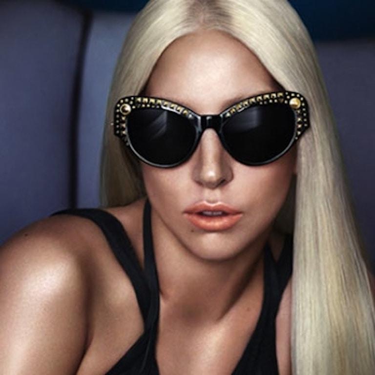 Elevate your sunglasses game with these funky Versace sunnies! Circa recent 2000s with Lady Gaga as the face for the campaign, these electric blue sunglasses feature a silver toned studded cat-eye frame with reflective blue lenses. Includes