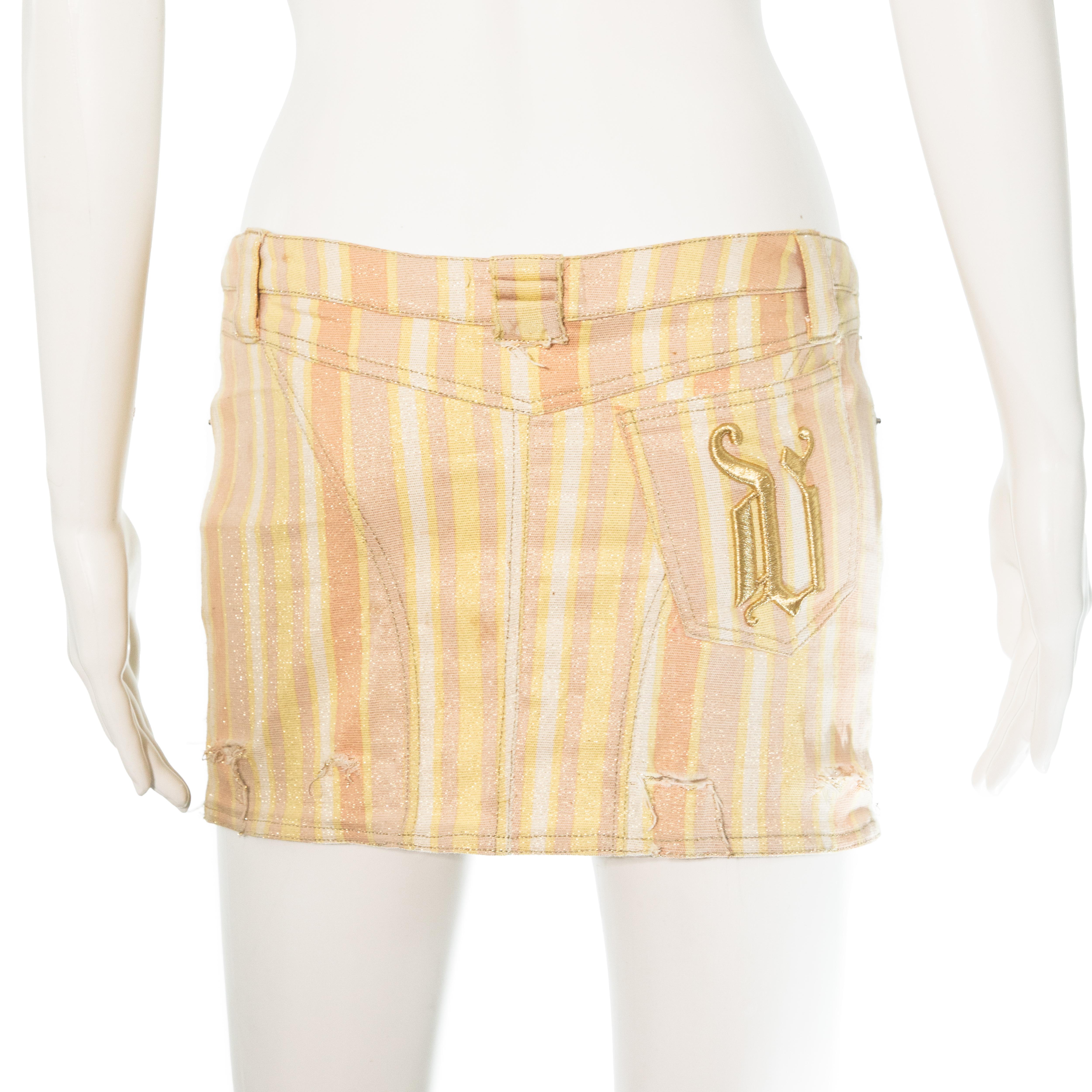Ruder Than The Rest presents a Versace mini skirt in sparkly metallic fabric.

Designed by Donatella Versace.

Distressed rips at the hem.

Embroidered 'V' on the back pocket.

Low rise fit.

Stretchy fabric.

Vintage, 2003.

Composition: