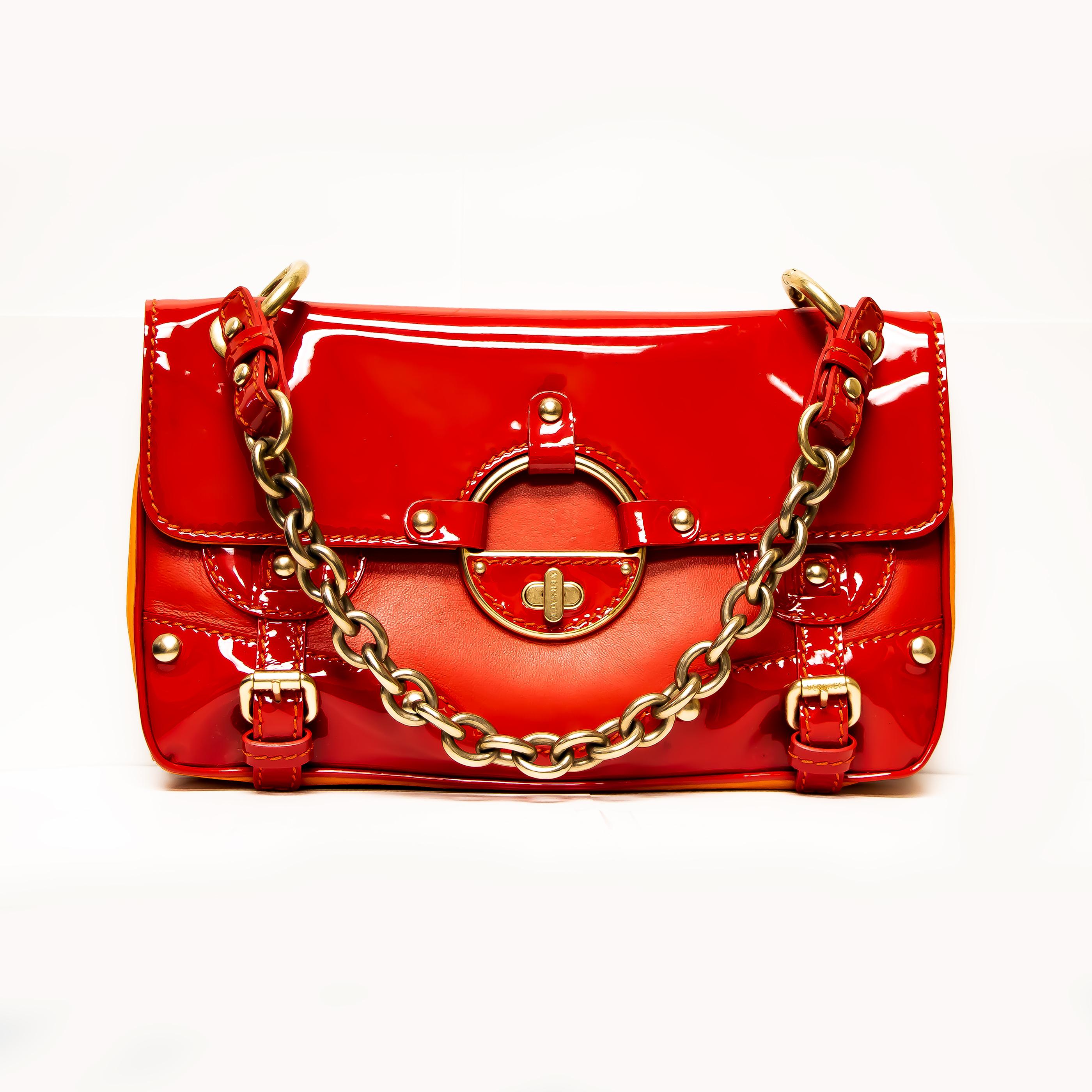 This 2010 Versace Collection Patent Leather Red/Gold/Orange is the kind of bag that can keep you in a smart and fabulous appearance even if going with your simplest ensemble. Its striking appearance exudes feminine appeal with a hint of hot look. It