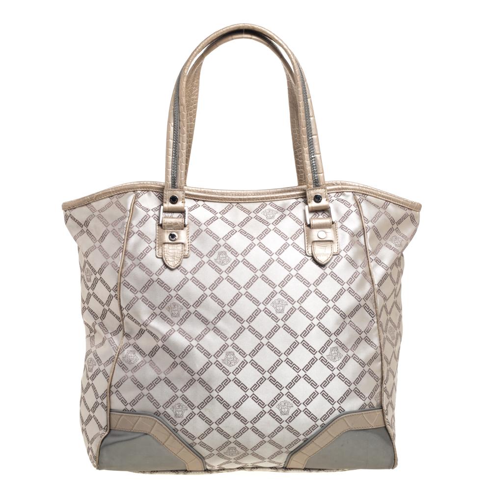 This fabulous tote by Versace is a bag ready to blend in with the busy lifestyle of the women of today. Meticulously crafted from monogram fabric and croc-embossed leather, it features a classy beige hue and dual top handles for you to parade it.