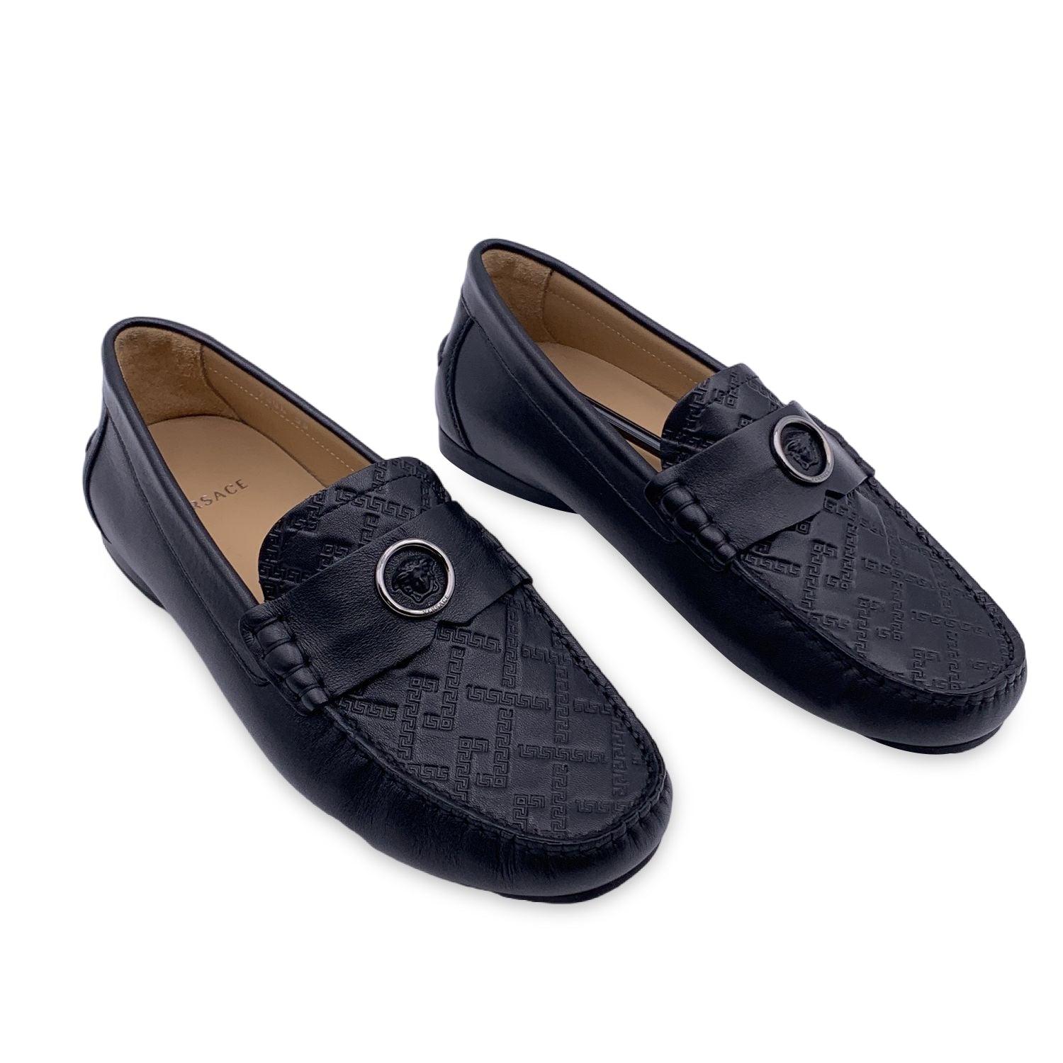 Beautiful Versace car shoes. Crafted in black leather with engraved greek and Medusa detailing on top. They feature a rounded toe and slip-on design. Rubber sole. Made in Italy. Size: EU 39 (The size shown for this item is the size indicated by the