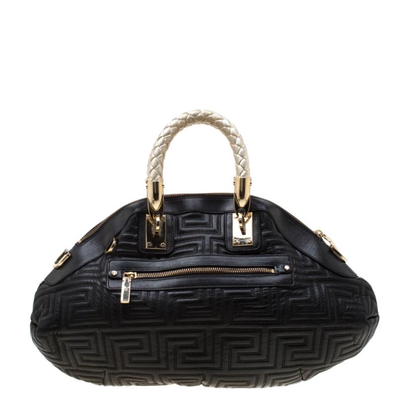 This Versace satchel carries an outstanding design and a fabulous interplay of leather and gold-tone hardware. It has a top zipper leading to a satin interior while being held by two braided handles. The quilt detailing and the brand label on the
