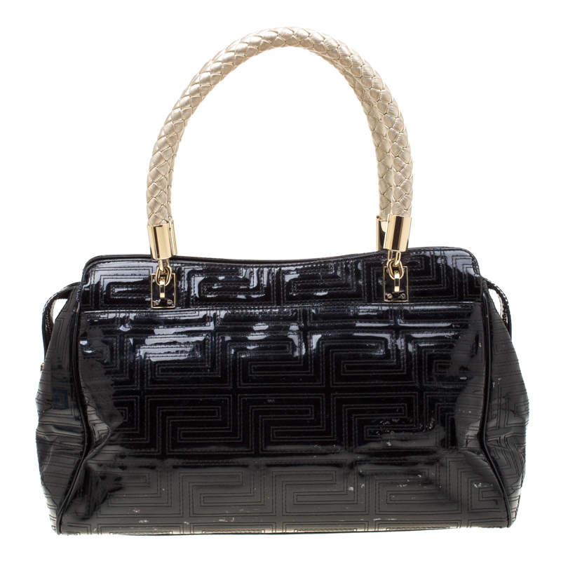 This bold and eye-catching Versace satchel is sure to make heads turn. Crafted from black quilted patent leather, the bag is accented with a gold-tone Gianni Versace Couture plate at the front. It features dual top braided handles and a top closure