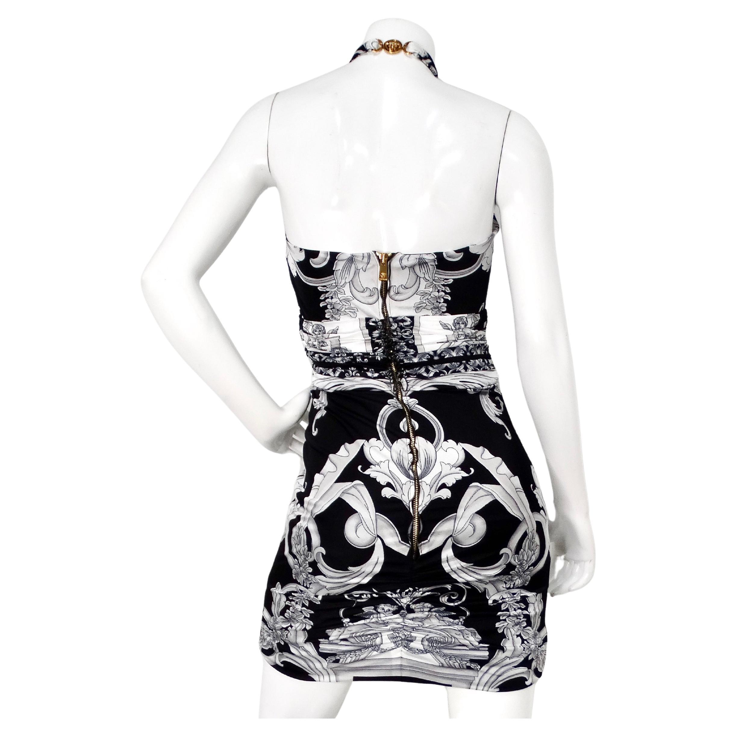 Il Versace Black & Grey Baroque Print Halter Dress è uno splendido esempio di moda di lusso che combina perfettamente l'opulenza classica con la raffinatezza moderna. Caratterizzato da un'accattivante stampa barocca nera e grigia, questo abito emana