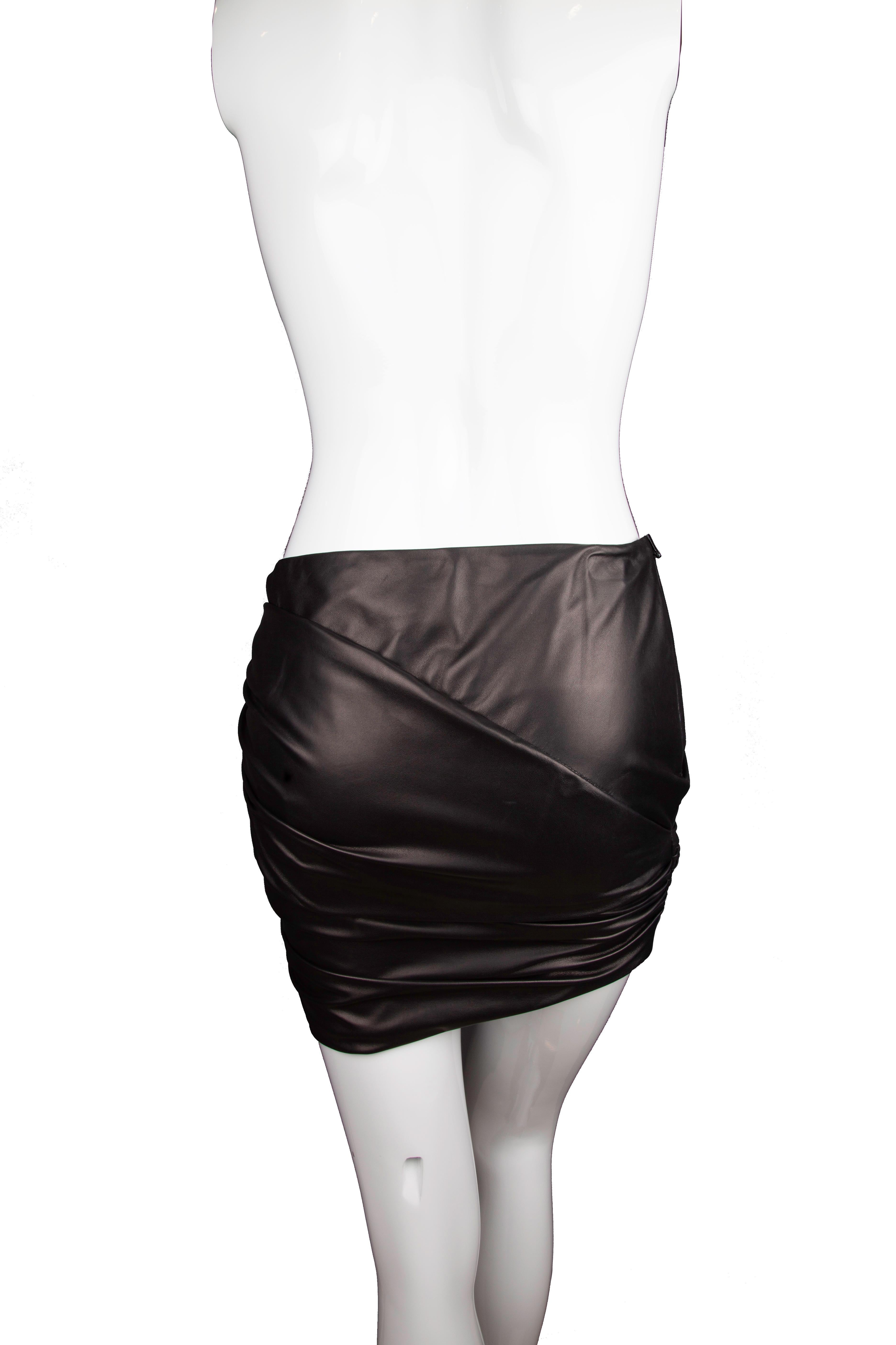 This Versace black mini skirt features asymmetric ruching, lambskin leather and a side zip fastening. This classic piece is a closet must-have. Brand new with tags. Made in Italy.

Size: 38 (IT)

Material: 
Outer: Lambskin Leather 100%, 
Lining: