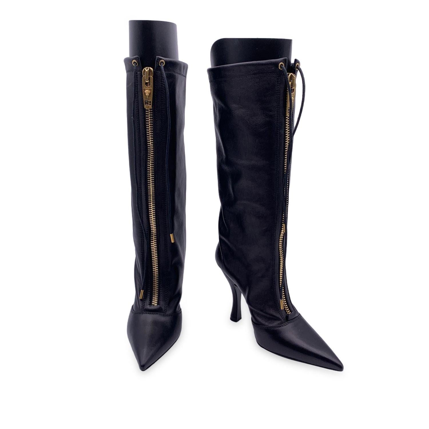 Versace black leather 3/4 length boot. It features gold metal central zip and a lace fastening. Pointed toes. Covered heels. heels height: 10.5 cm. Size: EU 36 (The size shown for this item is the size indicated by the designer on the shoes). Made