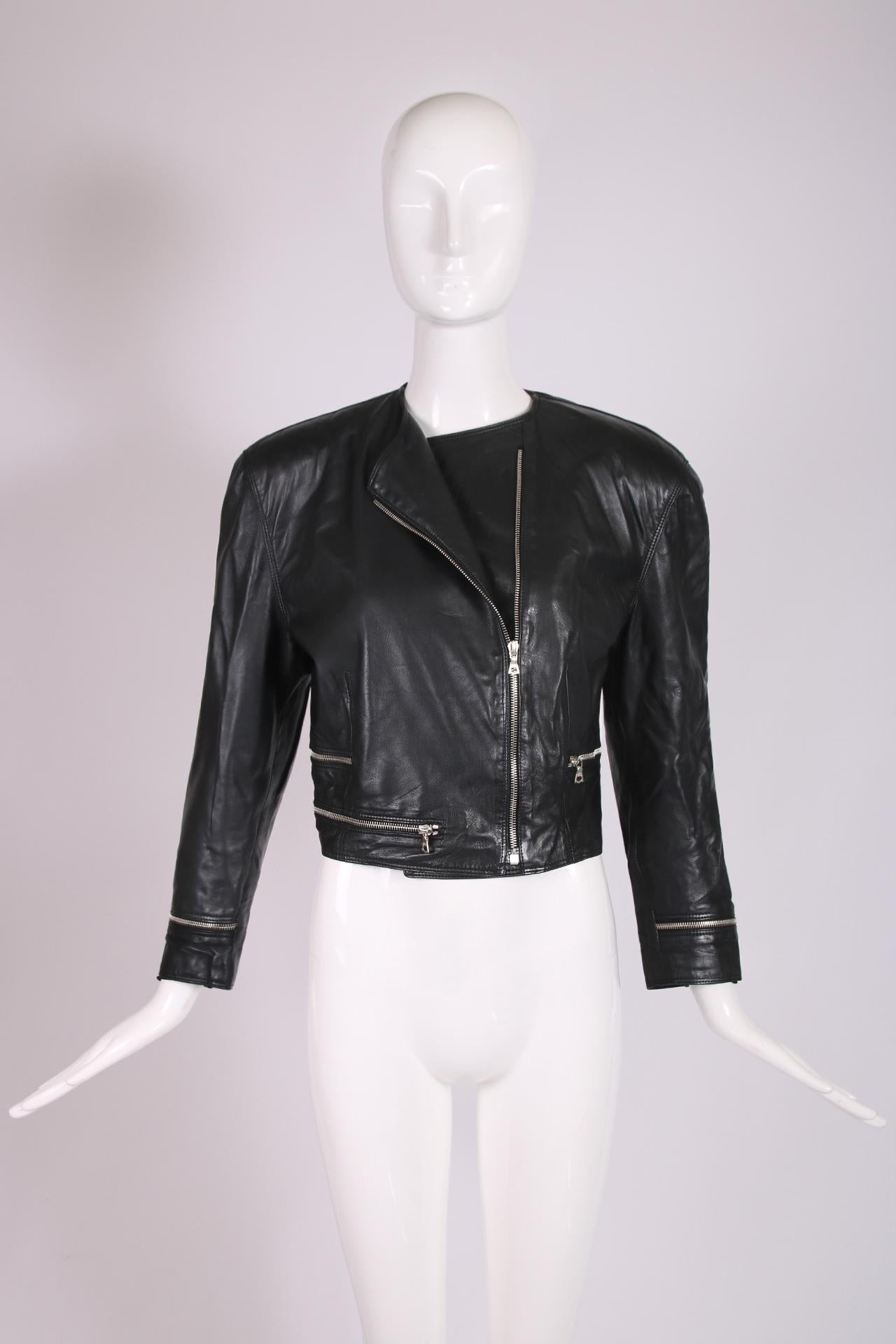Early 1990's Versace cropped black leather motorcycle jacket with a decorative zipper design motif at the cuffs and waist. The leather is incredibly soft and supple. There is no size tag but the interior is lined. In excellent condition - please