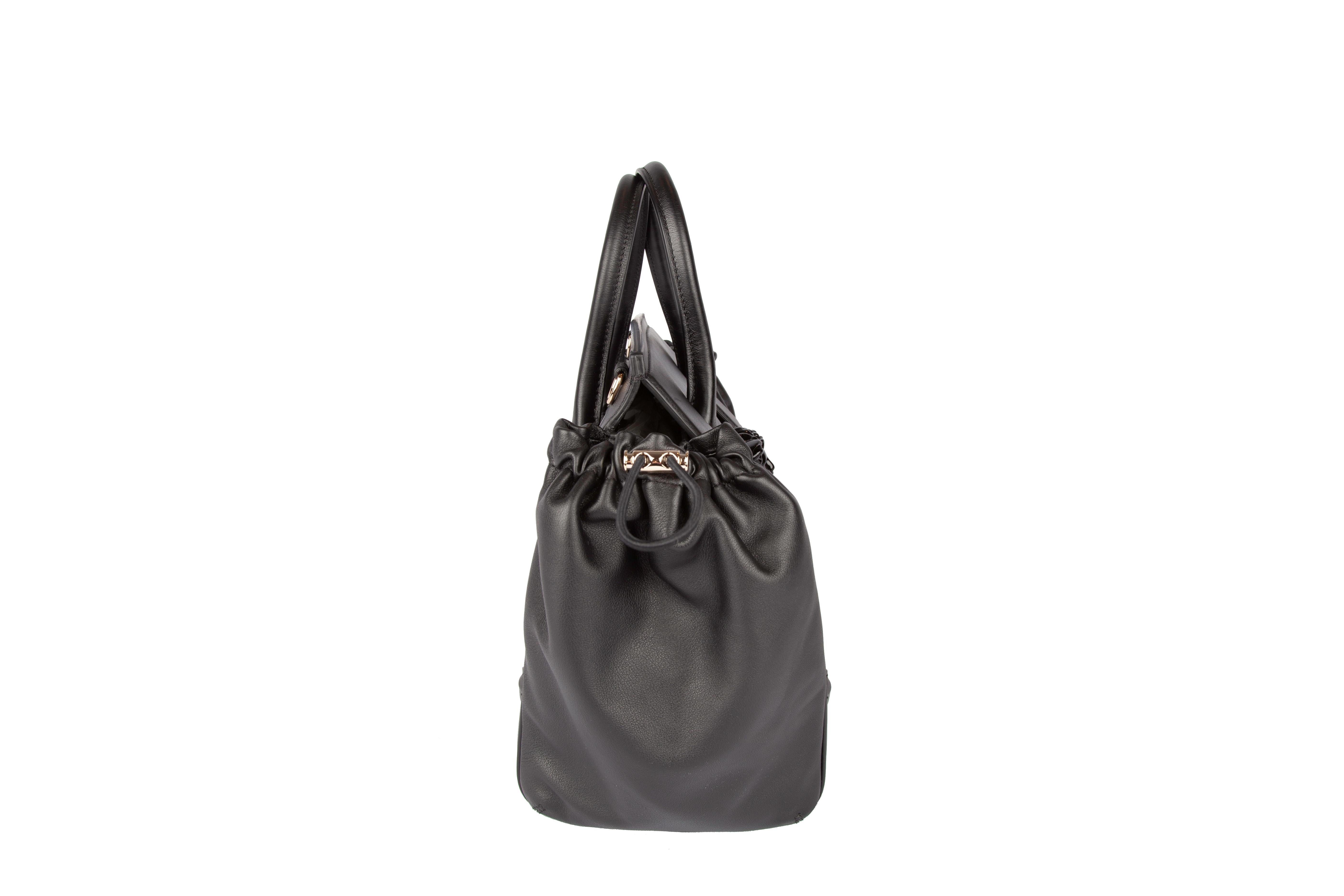 This Versace black leather Palazzo bag features top handle straps, 2 detachable and adjustable strap options, a magnetic snap fastening, and 2 side pouches. A versatile, everyday bag that displays the iconic Versace medusa head front and center.