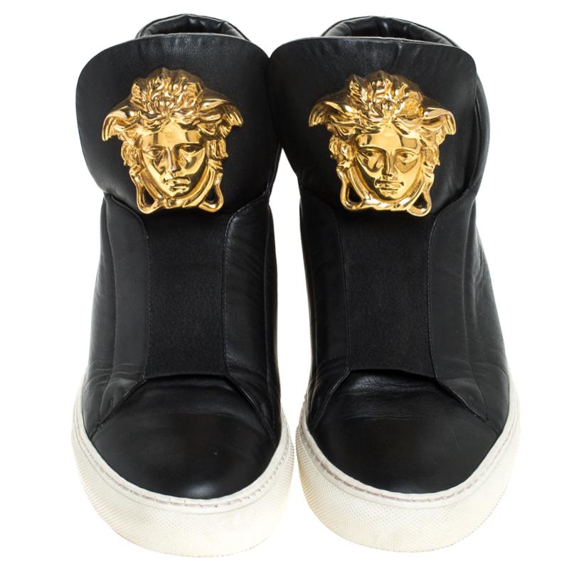 These sneakers from Versace are effortlessly suave and amazingly stylish. Brimming with fabulous details, these black sneakers are crafted from leather into a high-top silhouette and feature a gold-tone Medusa logo at the tongue. Comfortable soles