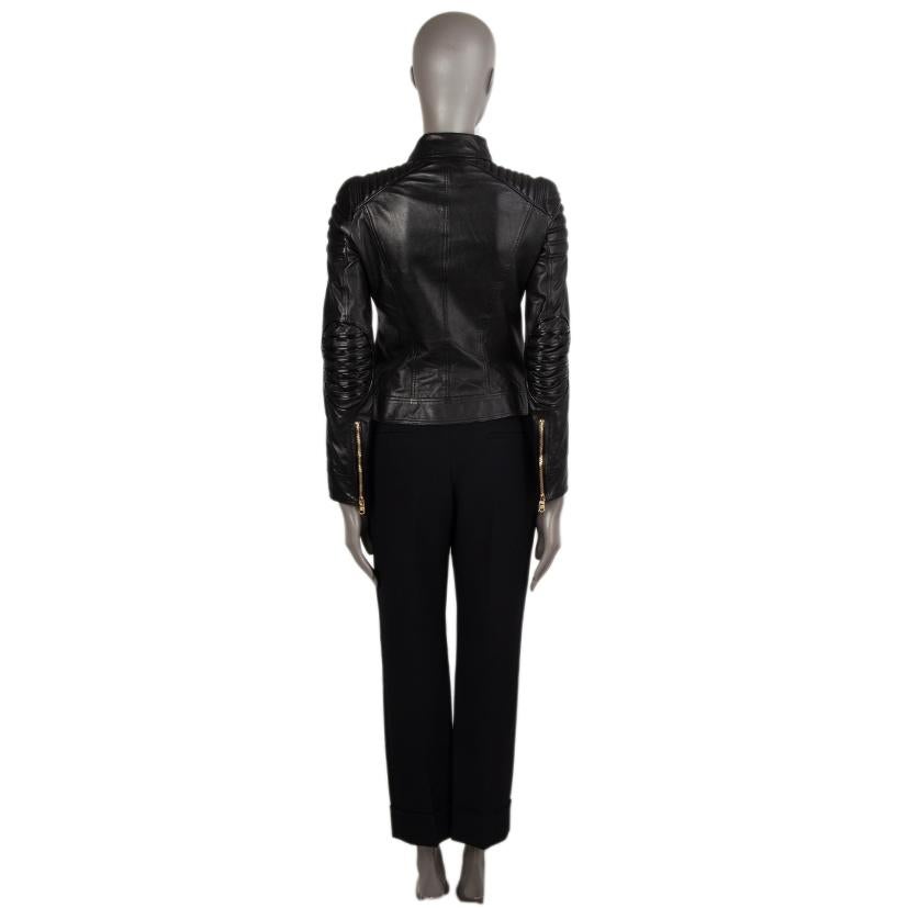 100% authentic Versace double-breasted biker jacket in black leather. With stripe quilting on the shoulders and elbow patches, zipper sleeves, and two slit pockets on the front. Closes with gold-tone zipper on the front. Lined in black rayon (96%)