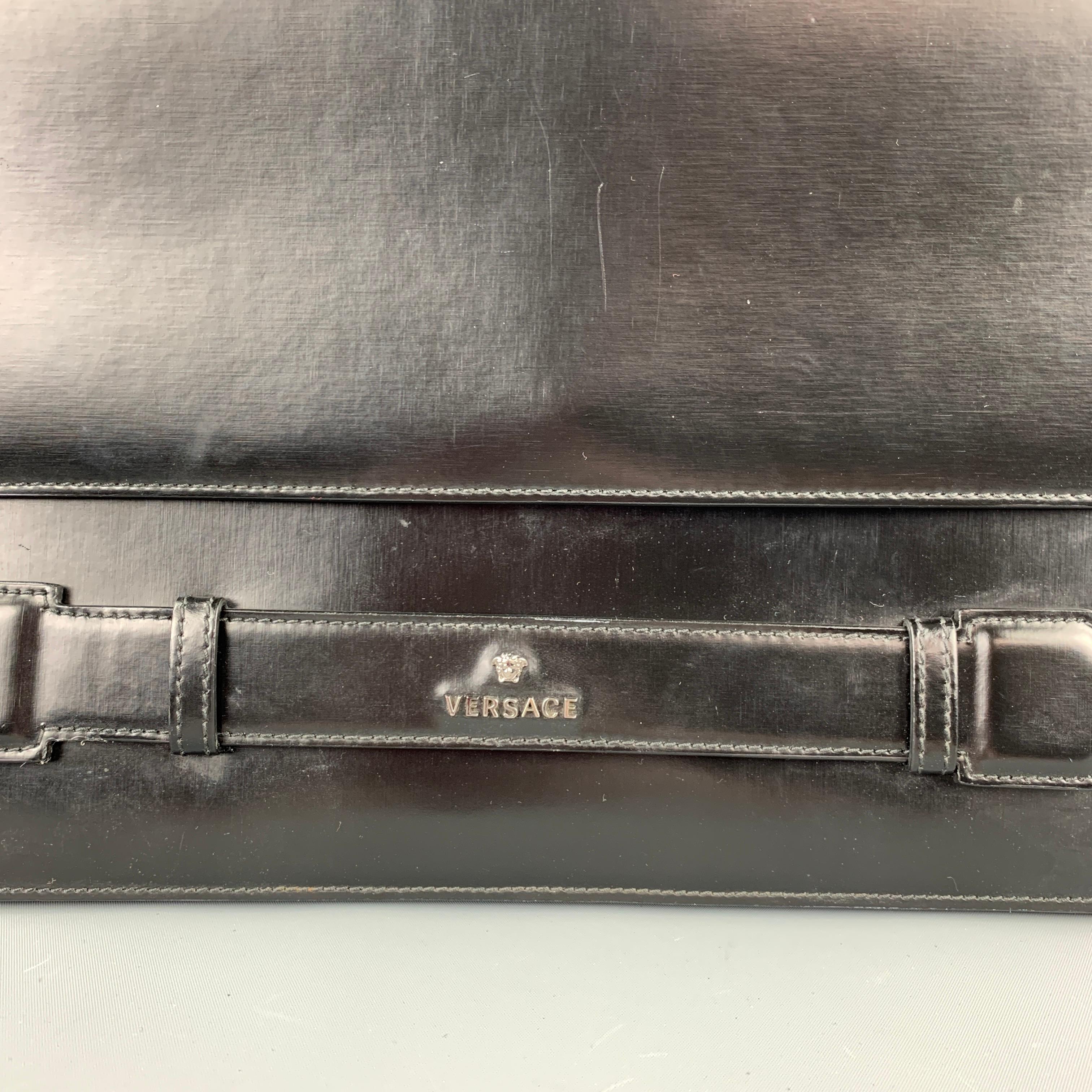 VERSACE bag comes in a black leather with a silver tone logo hardware detail featuring a envelope style, inner slots, and a snap button closure. Comes with a dust bag. Made in Italy.

Excellent Pre-Owned Condition.
Original Retail Price:
