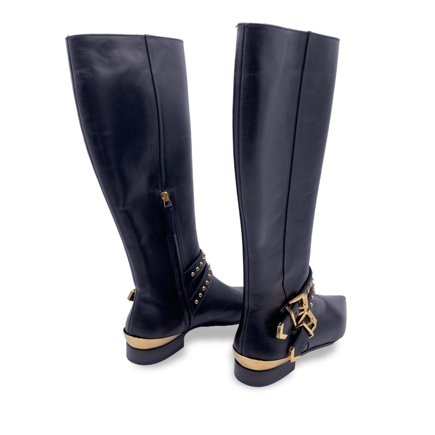 Versace black leather boot. It features gold metal detailing such as studs, 2 buckles at the ankle and the pointed toes. Zip closure internally. Size: EU 6 (The size shown for this item is the size indicated by the designer on the shoes). Made in