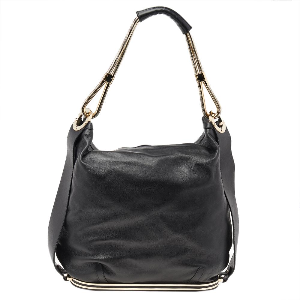 The simple silhouette and the use of black leather for the exterior bring out the appeal of this Versace shoulder bag. It features a shoulder handle, gold-tone hardware, and a fabric-lined interior.

